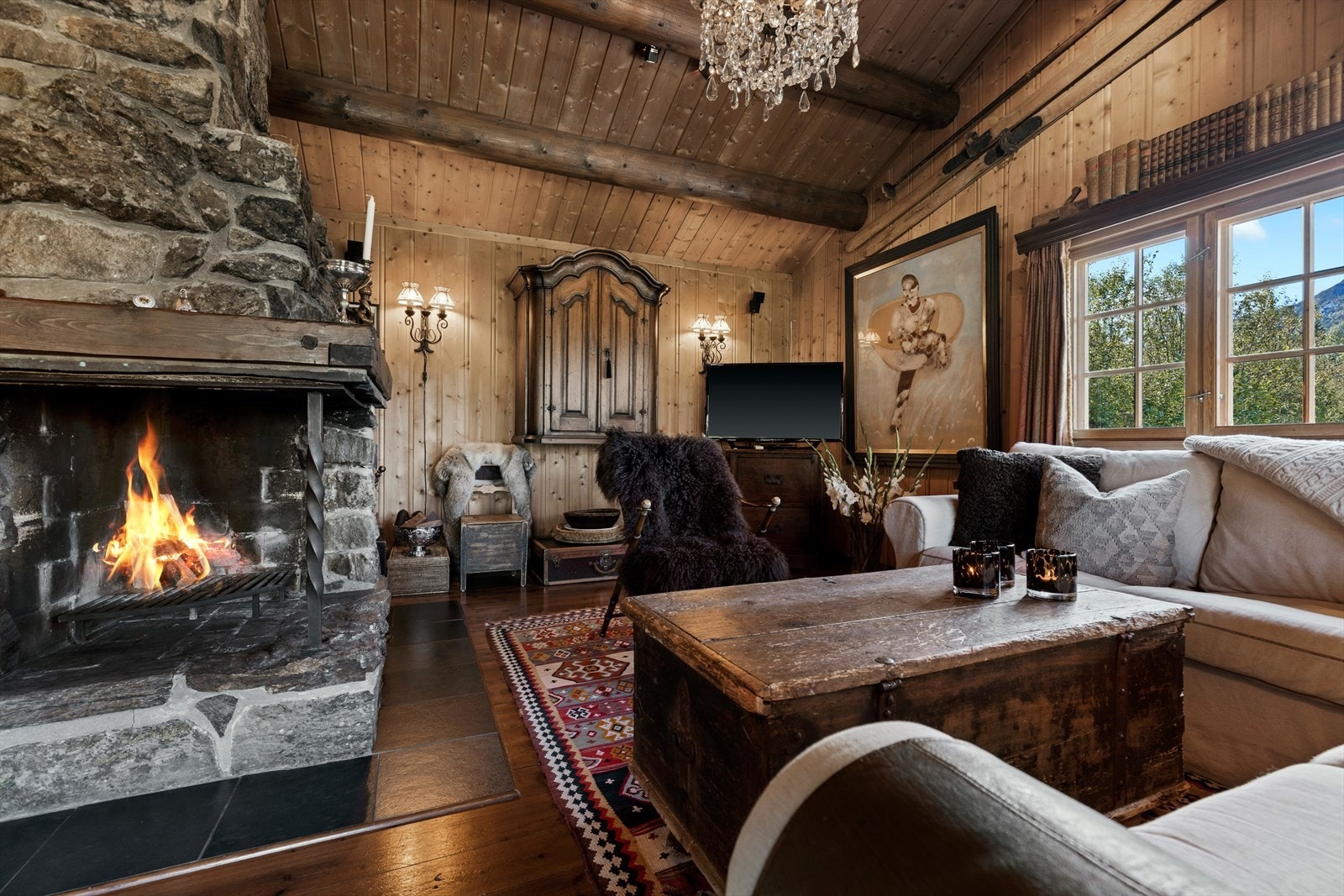 Hyggelig stue med raustatak og flott peis sentralt plassert. Galleribilde