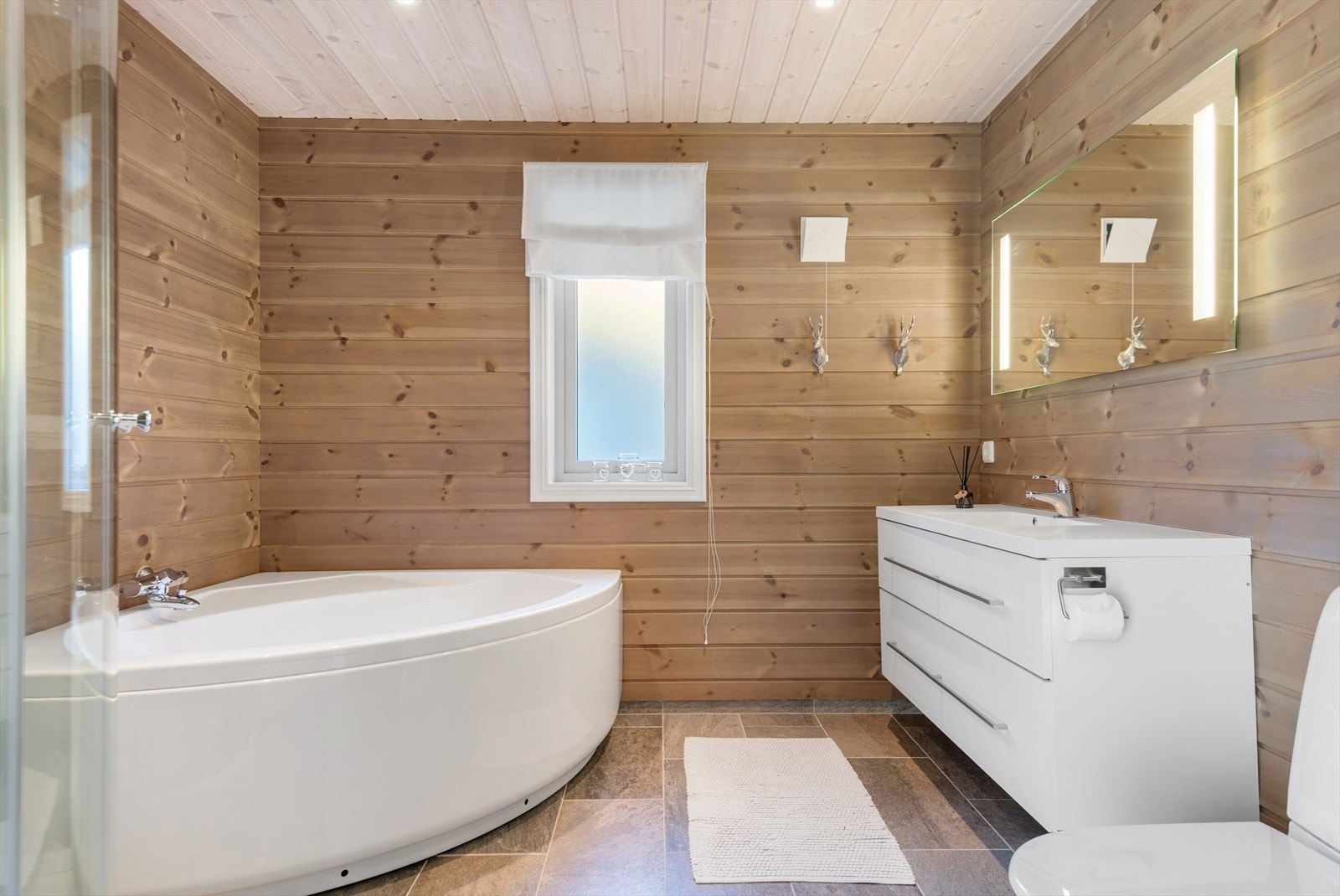 Stort og lekkert bad med fliser på gulv og varmekabler Galleribilde