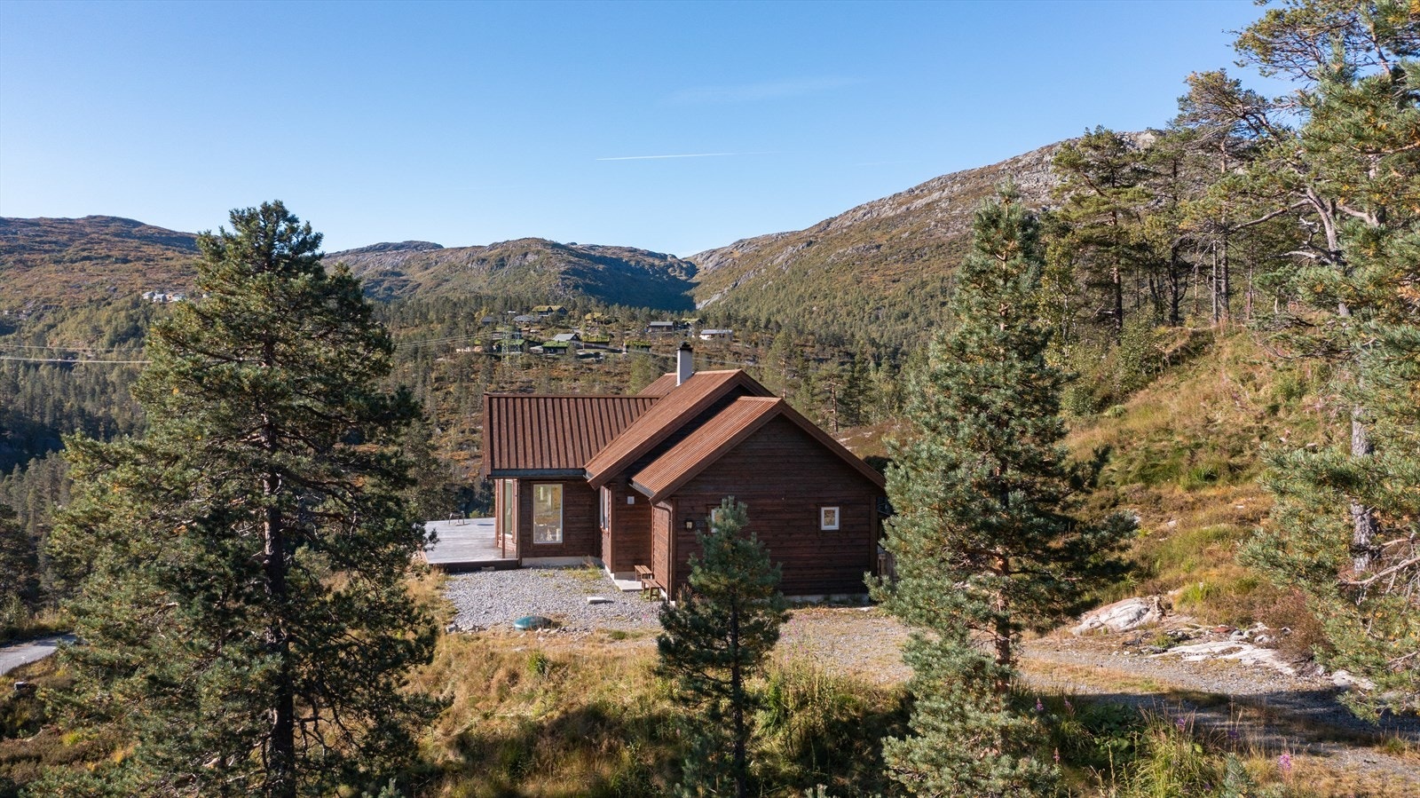 Tomten er opparbeidet med grus/gress på gårdsplass og stor terrasse Galleribilde
