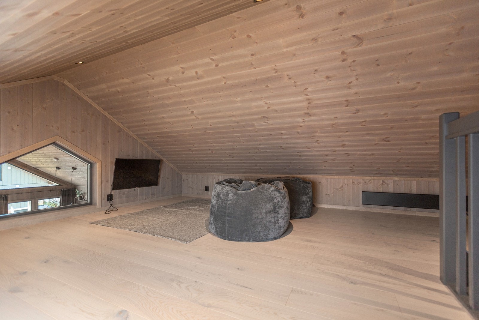 På hemsen er det en fin loftstue med skråhimling og vindu på kortveggen som både gir lys inn og utsyn over stue og kjøkken i etasjen under Galleribilde