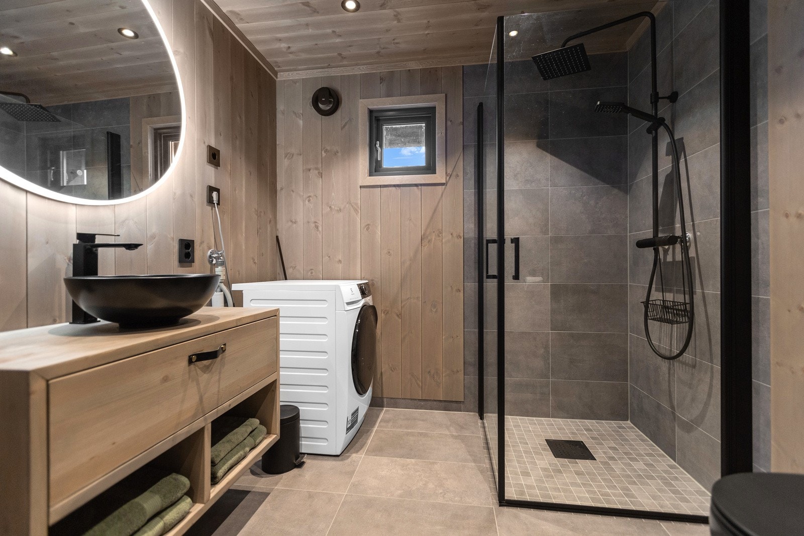 Innredningene er laget av møbelsnekker og er i heltre med glatt skuffefront, hyller i underkant og sort, toppmontert skålservant Galleribilde