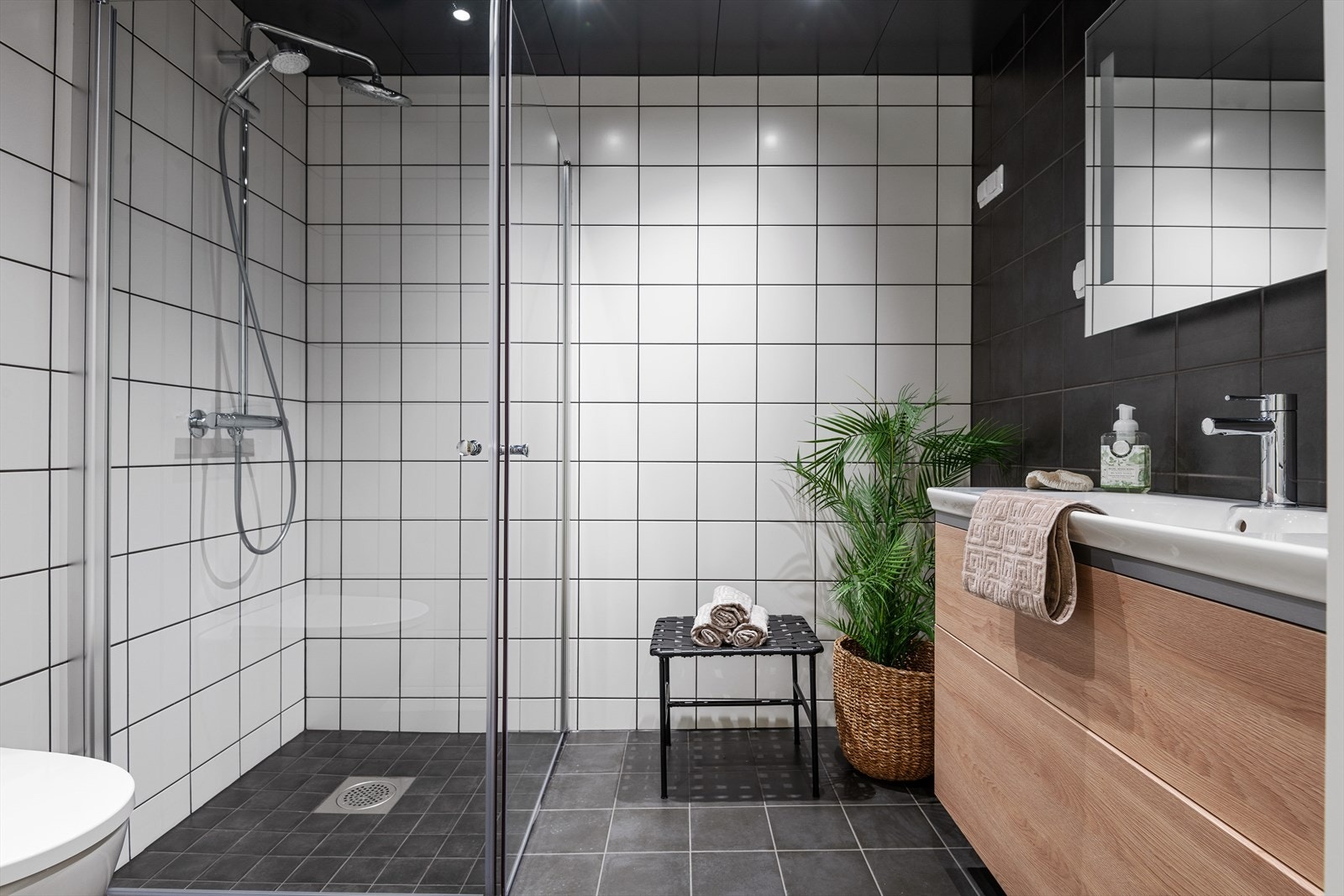 Lekkert baderom med delikate fliser, regnfallsdusj og flotte baderomsmøbler Galleribilde