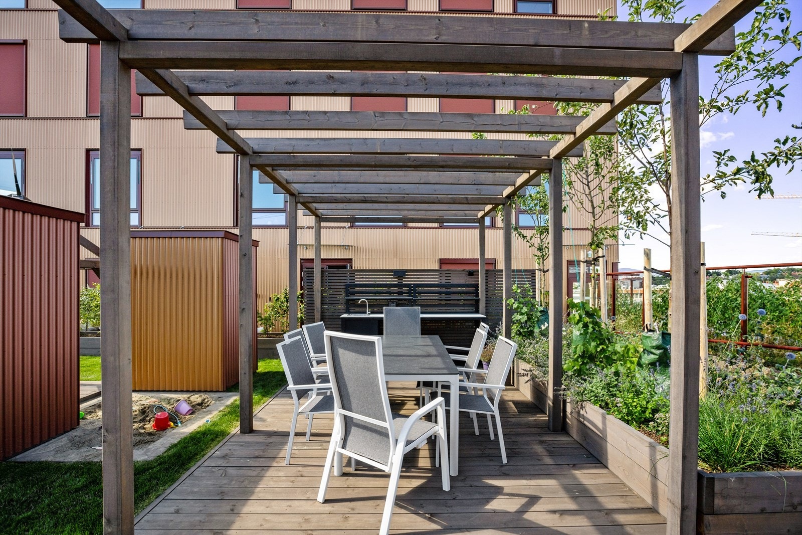 De felles takterrassene har flere sittegrupper, lekeplasser og utekjøkken Galleribilde