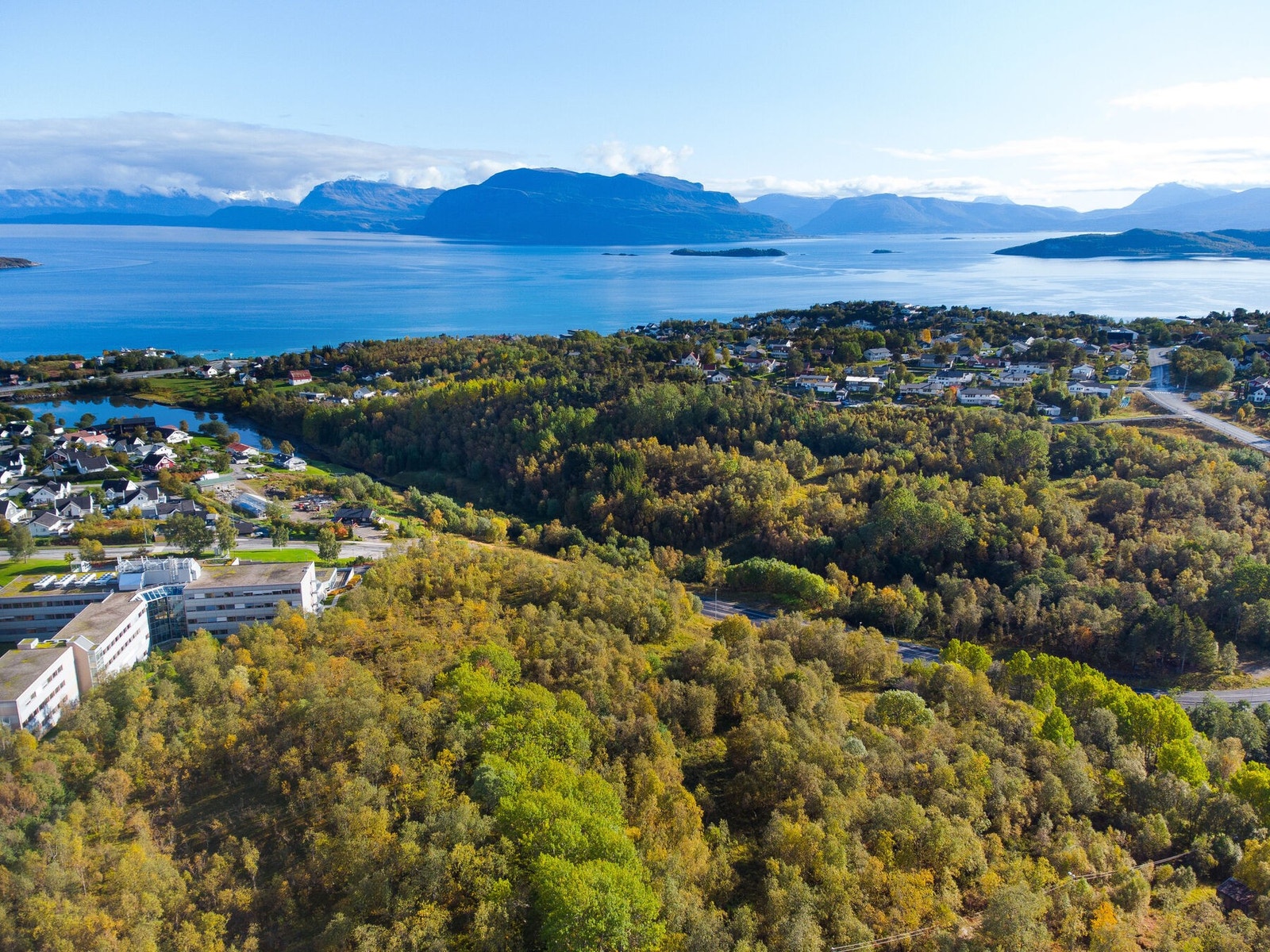 Tomtene ligger fint til på høydedraget ved siden av og bak Tianbygget Galleribilde