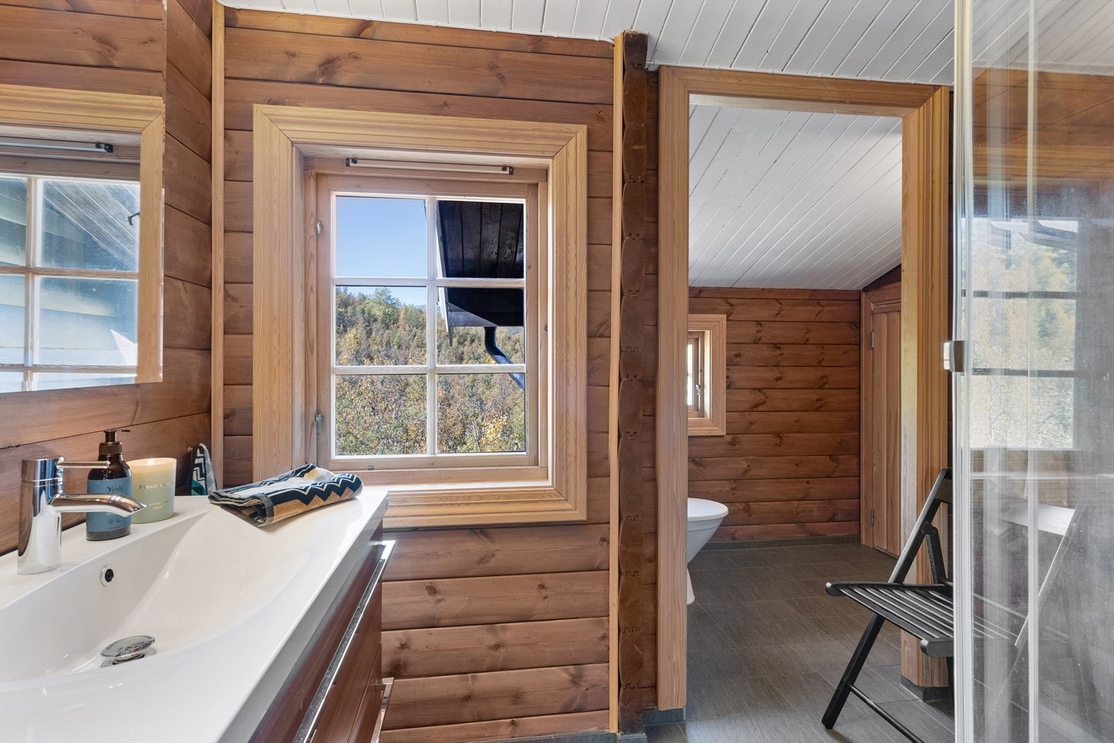 Innredning med servant, toalett og dusjkabinett. Fra badet er det tilgang til badstue, denne har nåværende eier kun brukt til bod. Galleribilde