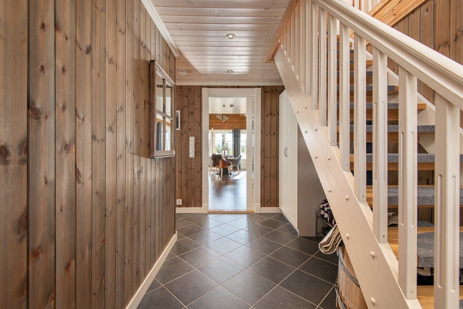 Romslig gang med trapp opp til hemsen. Flislagt gulv med varmekabler. Galleribilde