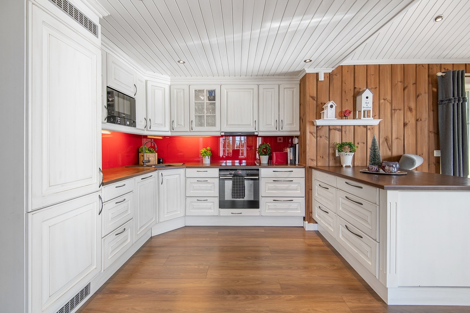 Kjøkkenet er snekkerlaget og i heltre utførelse med profilerte fronter. Rikelig med skap-og benkeplass. Galleribilde