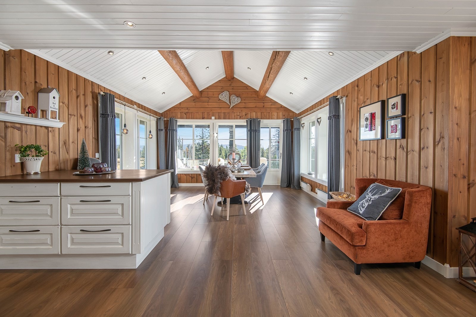 Lyst, innbydende og sosialt oppholdsrom der kjøkken og spiseplassen ligger i åpen løsning mot stue. Galleribilde