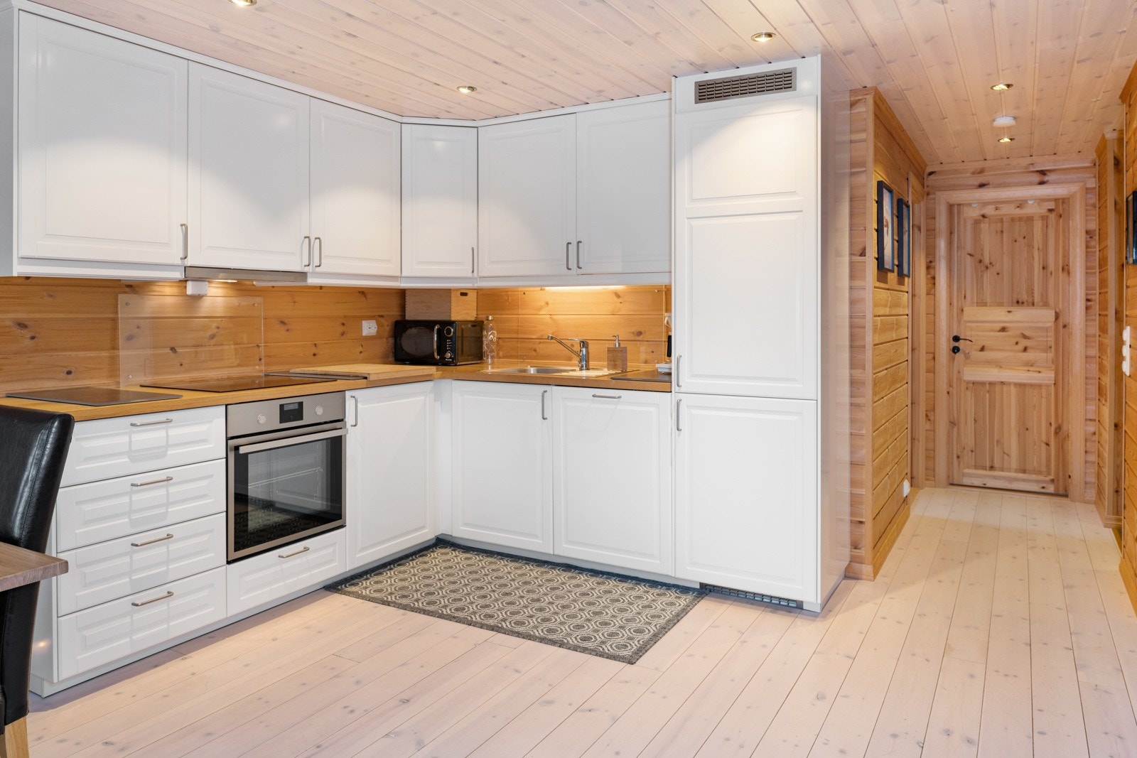 Strøkent, klassisk kjøkken med speil fronter på over- og underskap og laminert benkeplate. Galleribilde