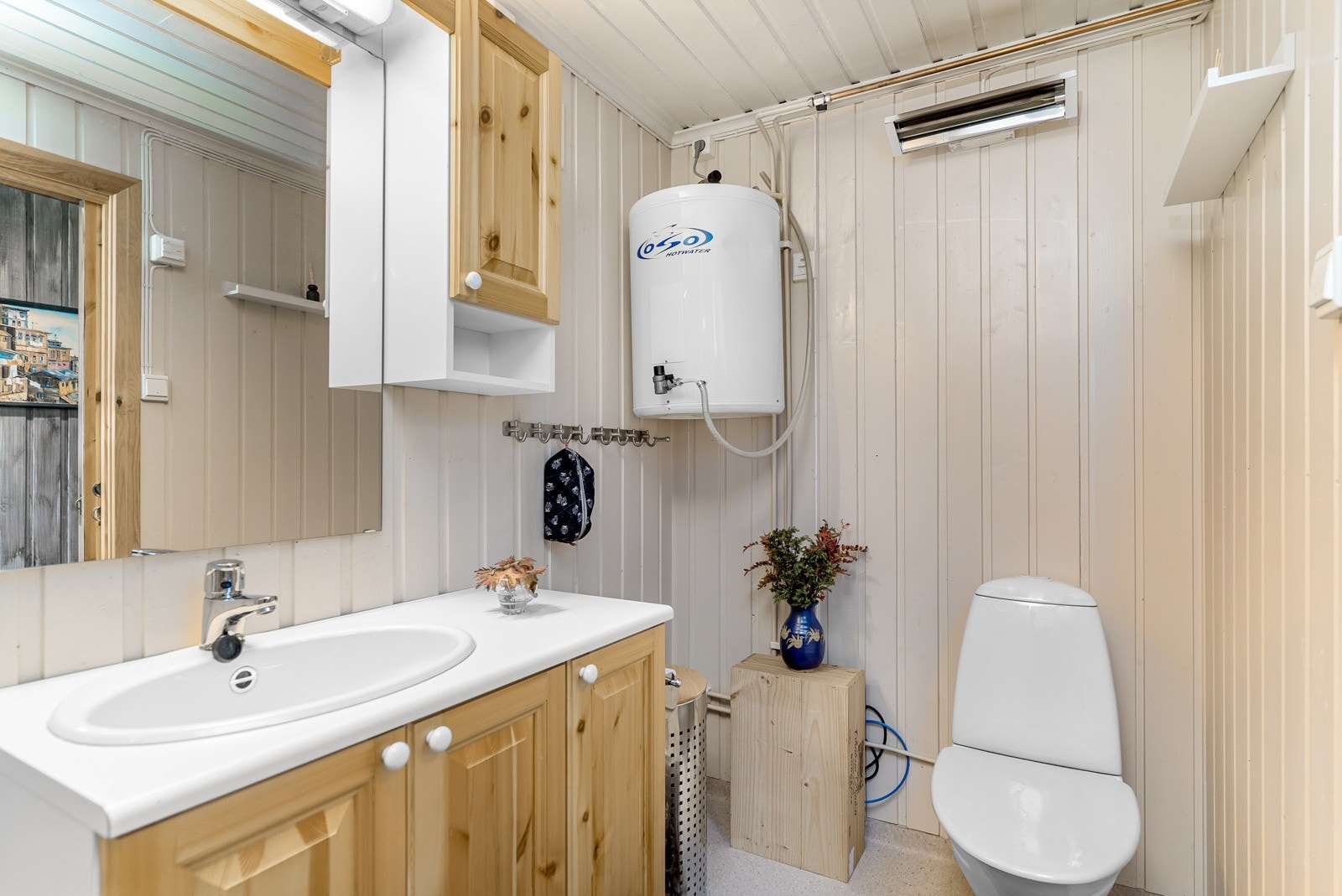 Badet har blant annet dusjkabinett med dusjarmatur, gulvstående toalett, speil med overlys og stikkontakt over servant. Galleribilde