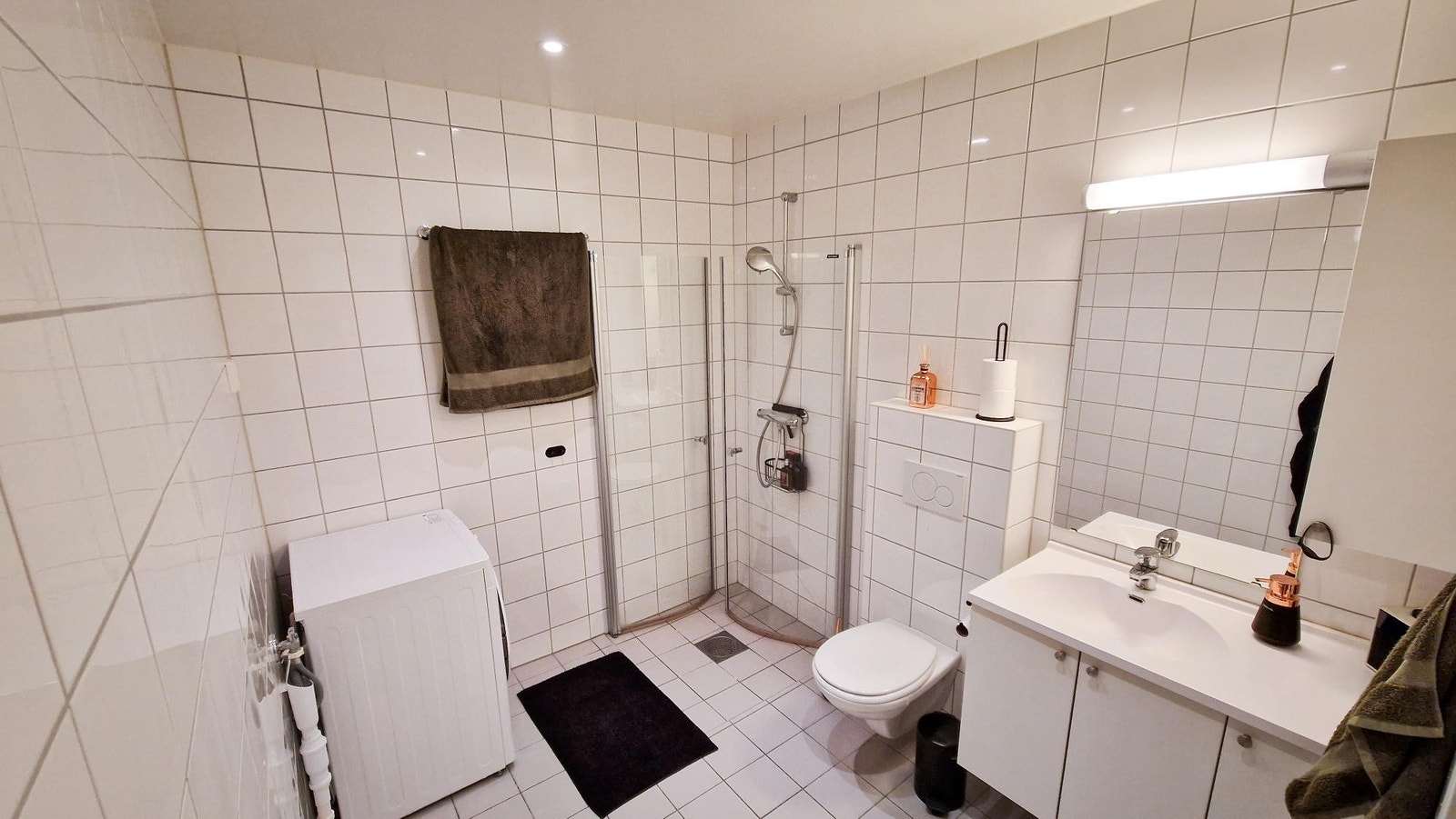 Stort bad med gulvvarme og plass til tørkeststativ. Lys over speilet og dimbare spotter i taket. Galleribilde