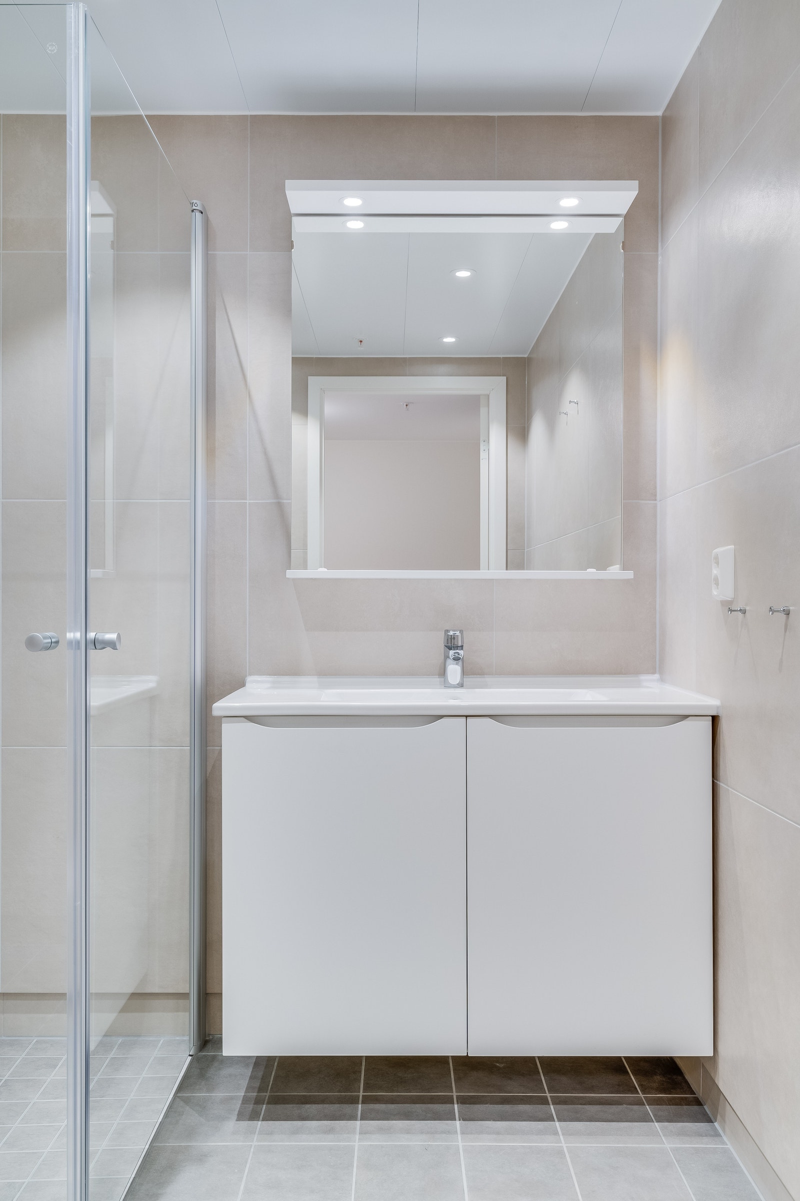 Heldekkende servant over innredning og speil med lys Galleribilde