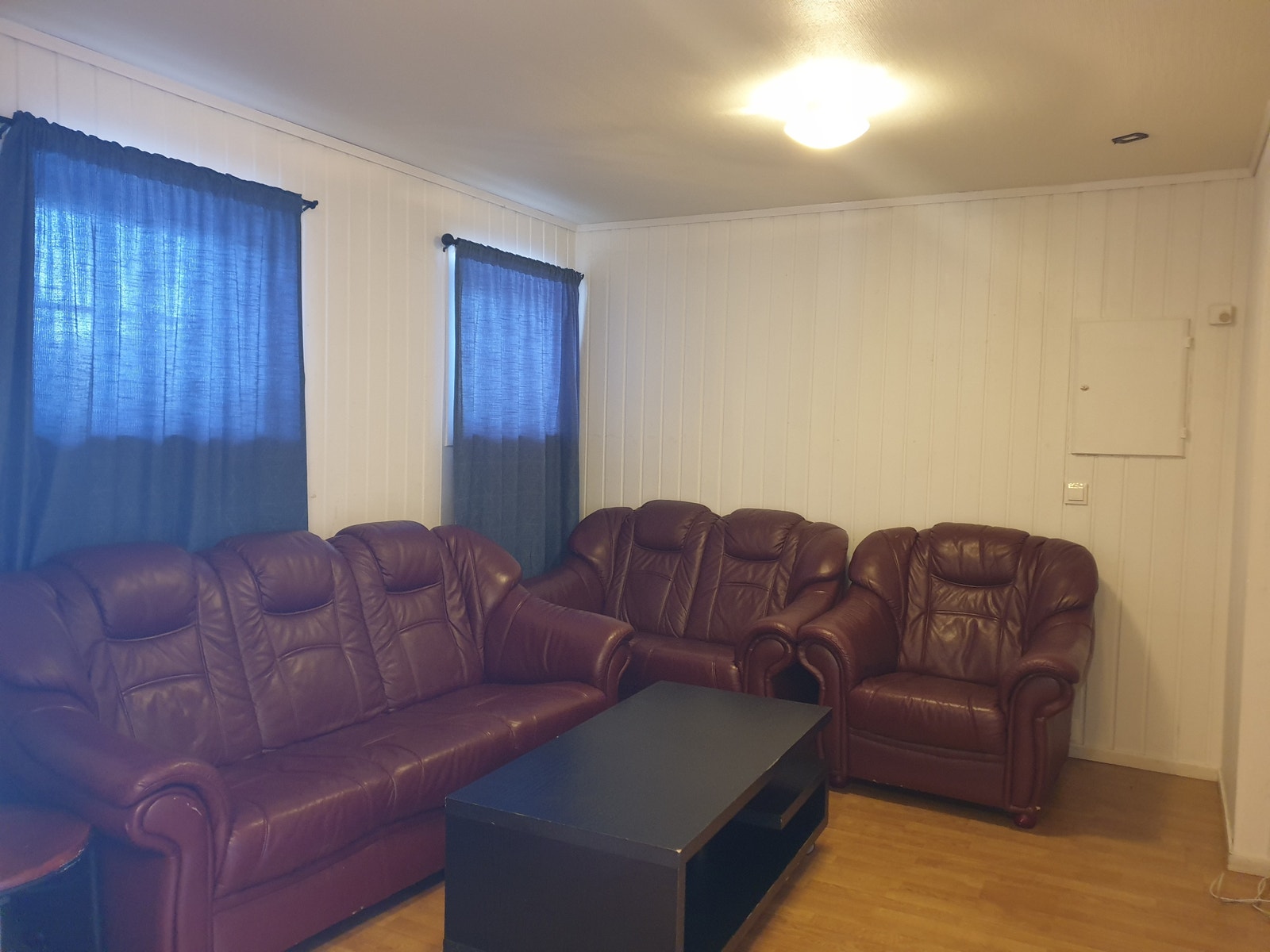 Stor åpen stueløsning med god plass til møbler. Kommer med sofa, bord og TV-stativ. Galleribilde