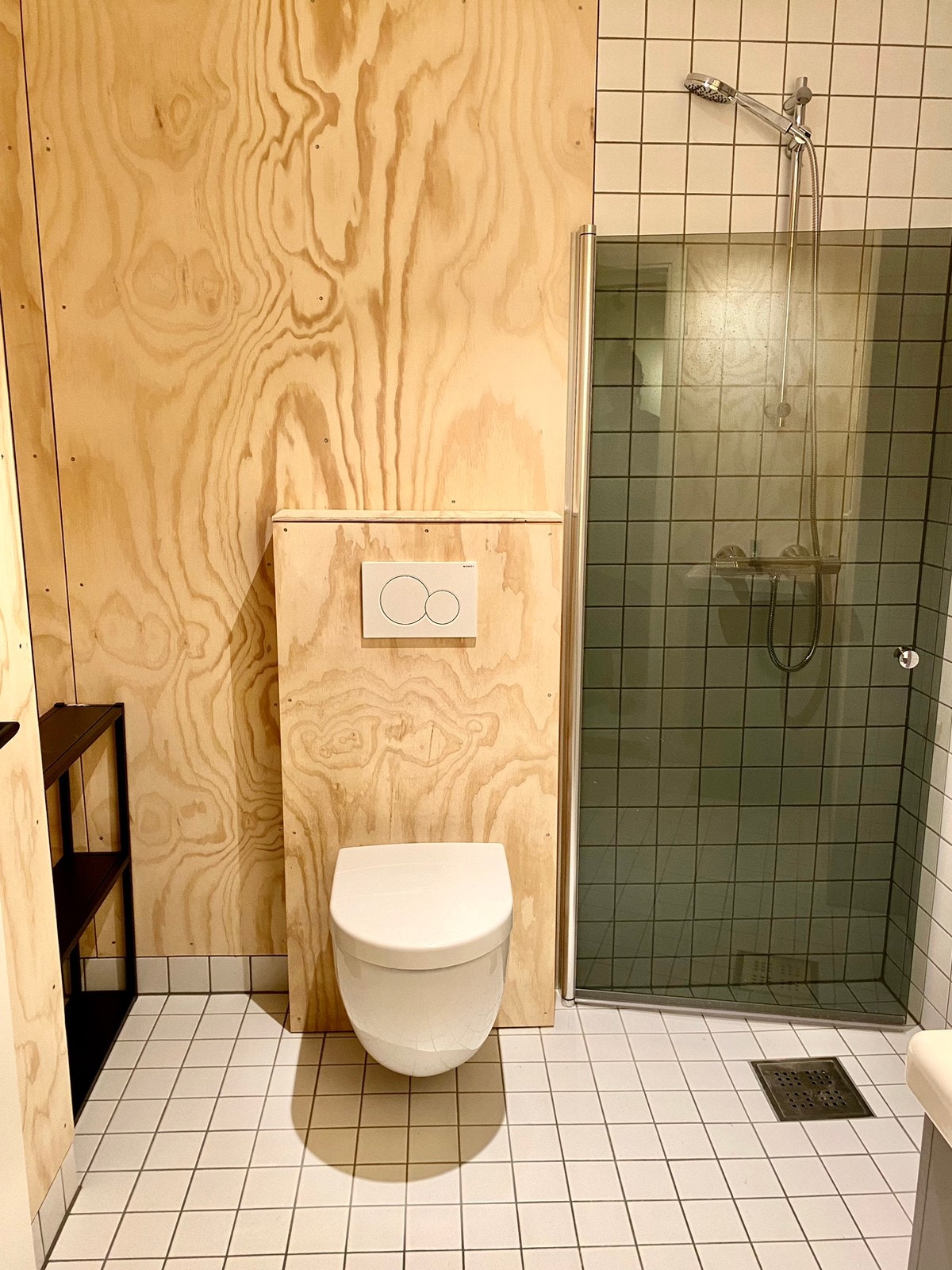 Flislagt bad med vegger i kryssfinér og vaskemaskin (ble montert etter bildet er tatt) Galleribilde