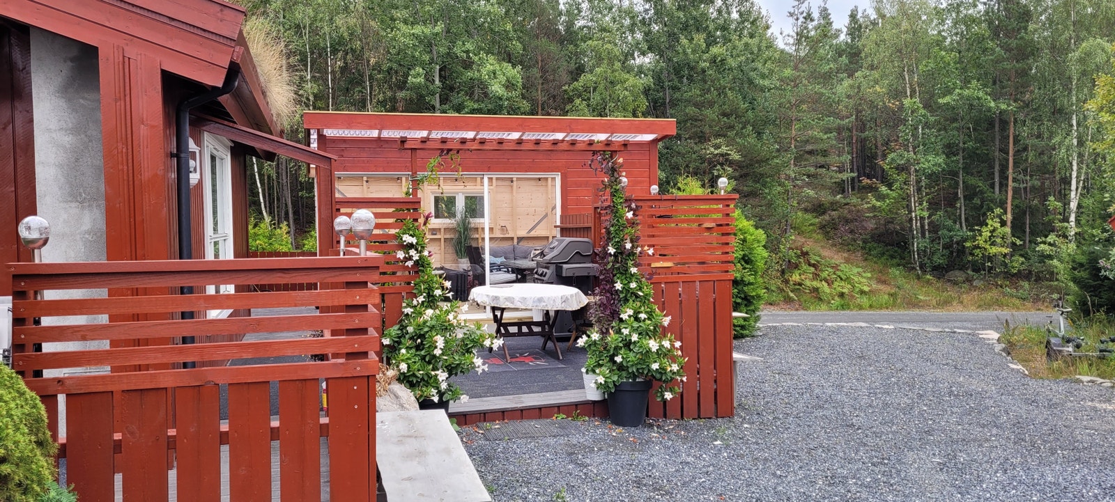 Stor terrasse i tillegg til utestue med store skyvedører i glass Galleribilde