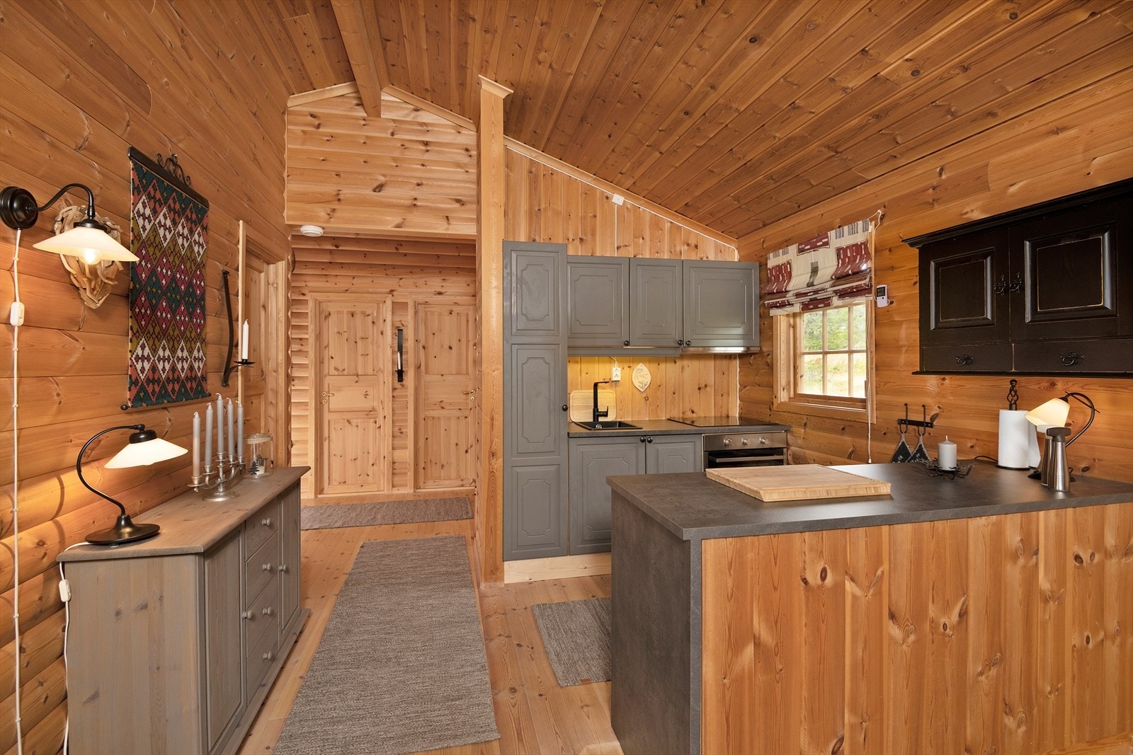 Kjøkken har innredning i heltre utørelse, malt i en tidsriktig og delikat gråtone. Galleribilde