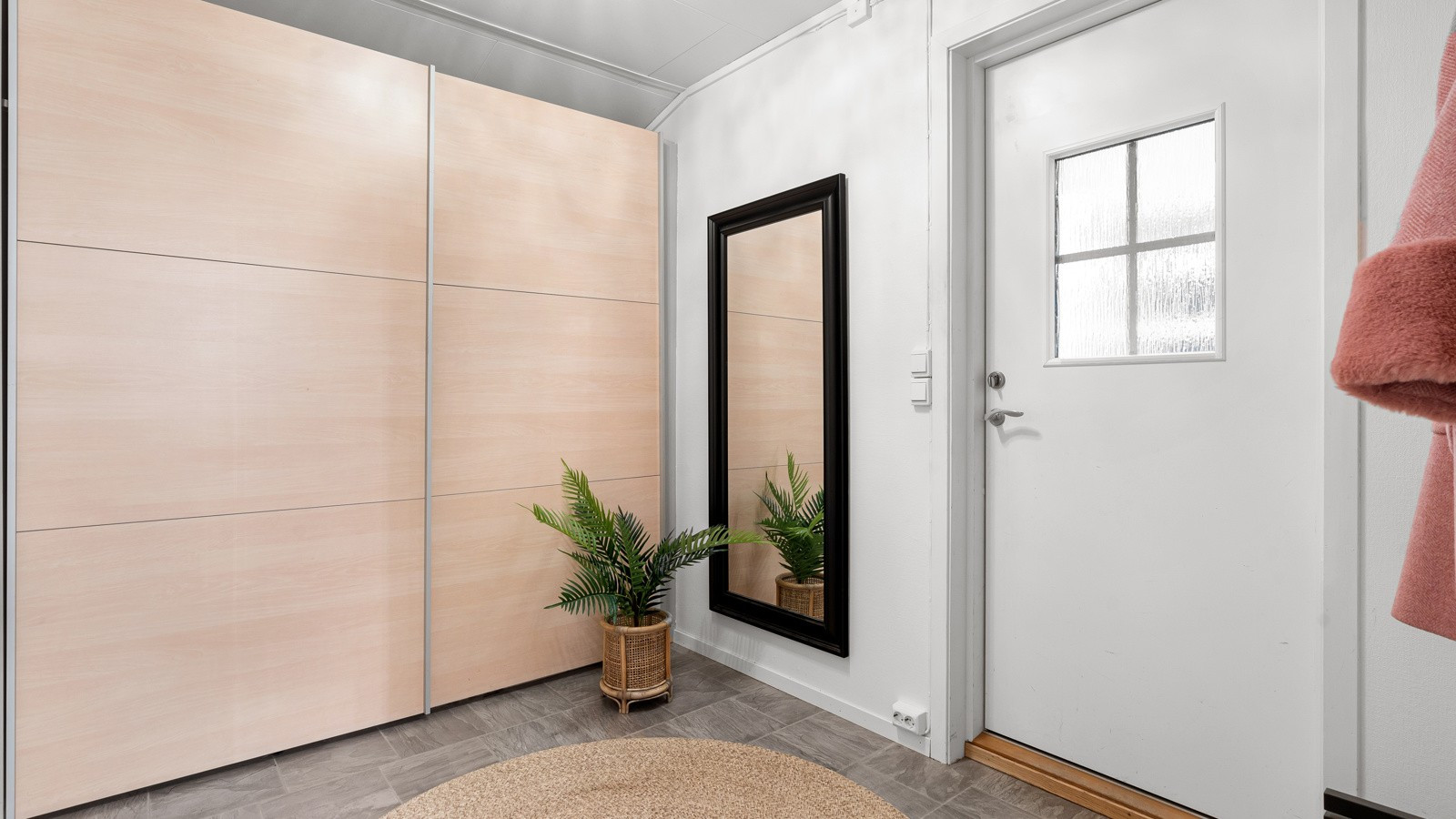 Romslig gang med skyvedørsgarderobe.