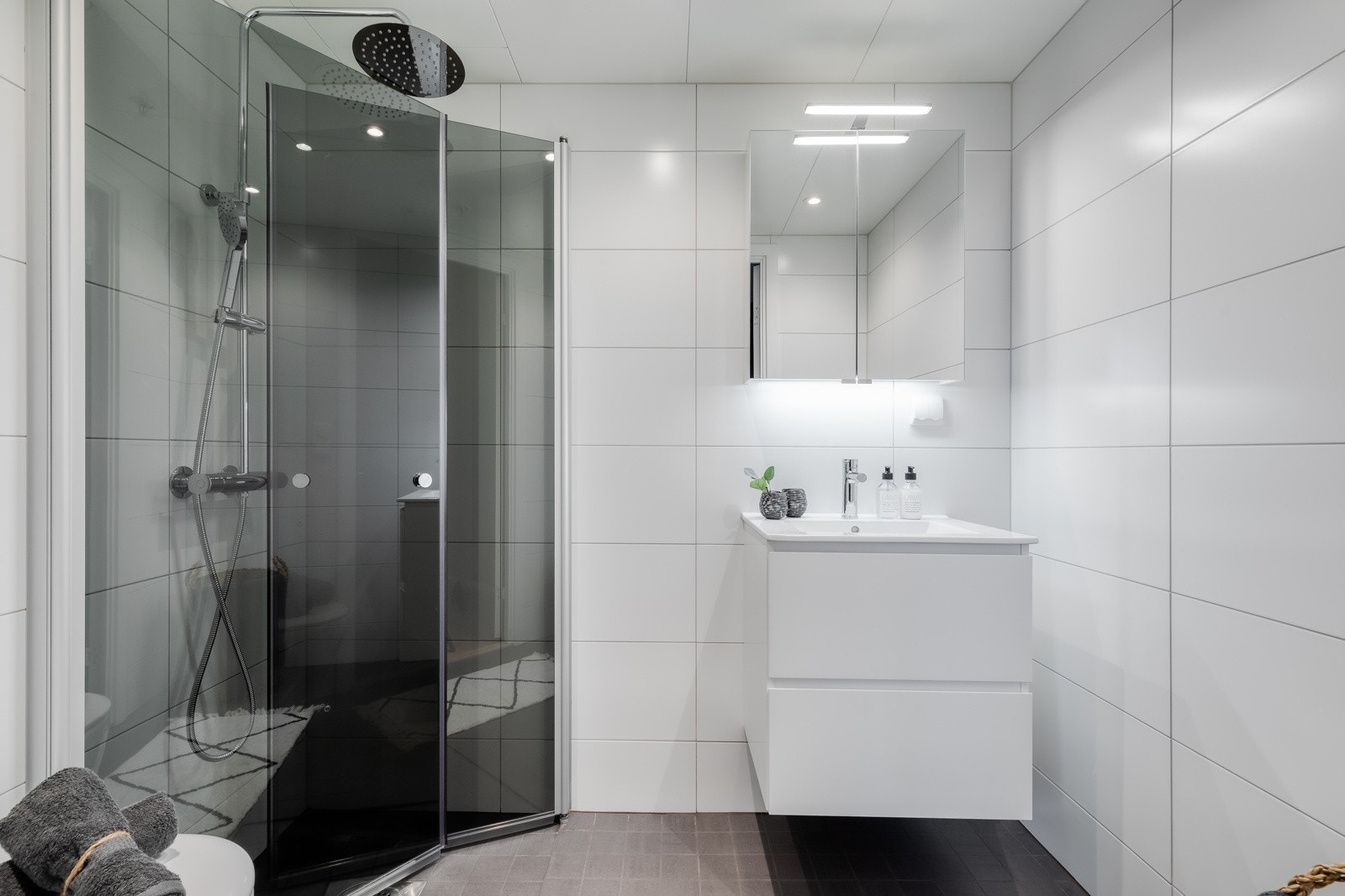 Dette badet er på ca. 3 kvm og består av vegghengt toalett, regnfalldusj med innfellbare dusjdører, servant med skuffeseksjon under, samt speilskap med belysning over. Galleribilde