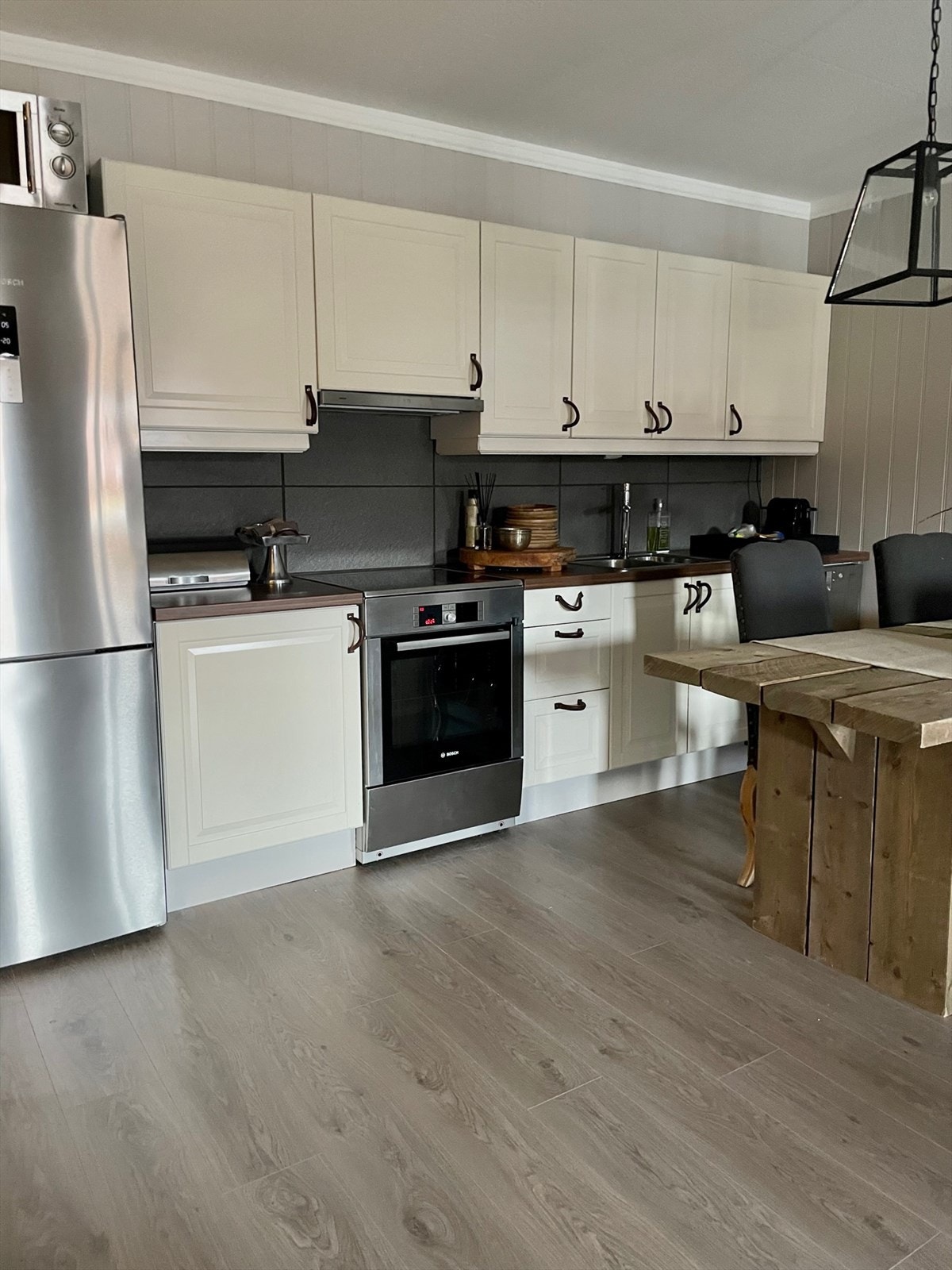 Et effektivt kjøkken med åpen løsning for hvitevarer. Hvitevarene medfølger i salget Galleribilde