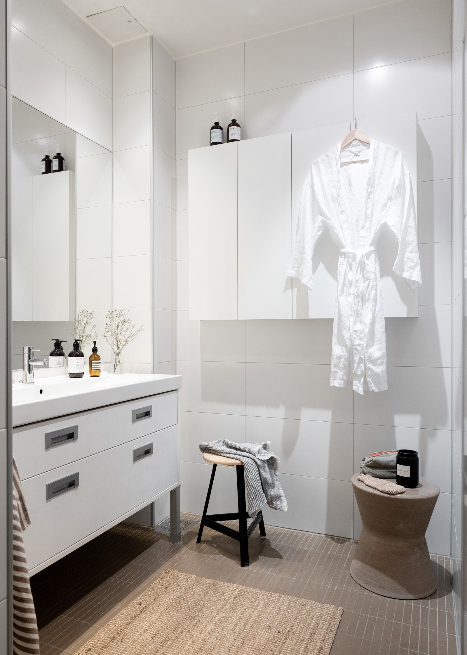 Innredningen består av skapinnredning med to glatte skuffe-fronter, heldekkende avlang hvit servant og et stort speil på vegg over servant. Galleribilde