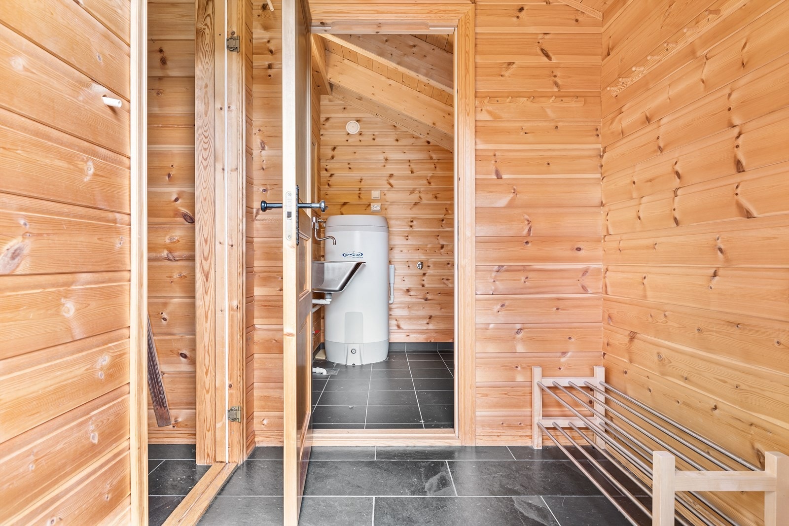 Entre/gang med fliser på gulv. Adkomst til vaskerom med utslagsvask og opplegg for vaskemaskin. Galleribilde