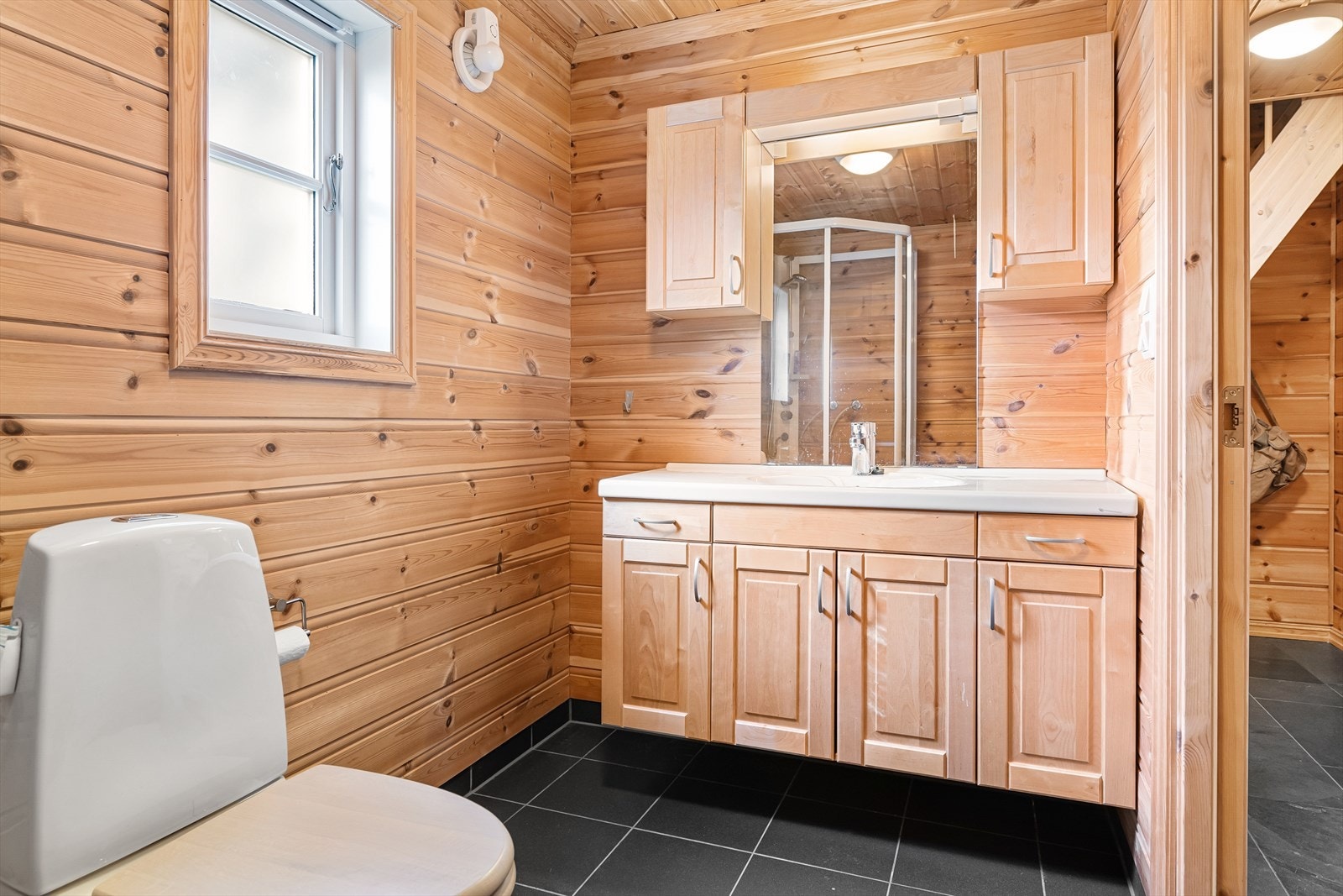 Bad med fliser på gulv med varmekabler. Dusjkabinett, wc og vask. Galleribilde