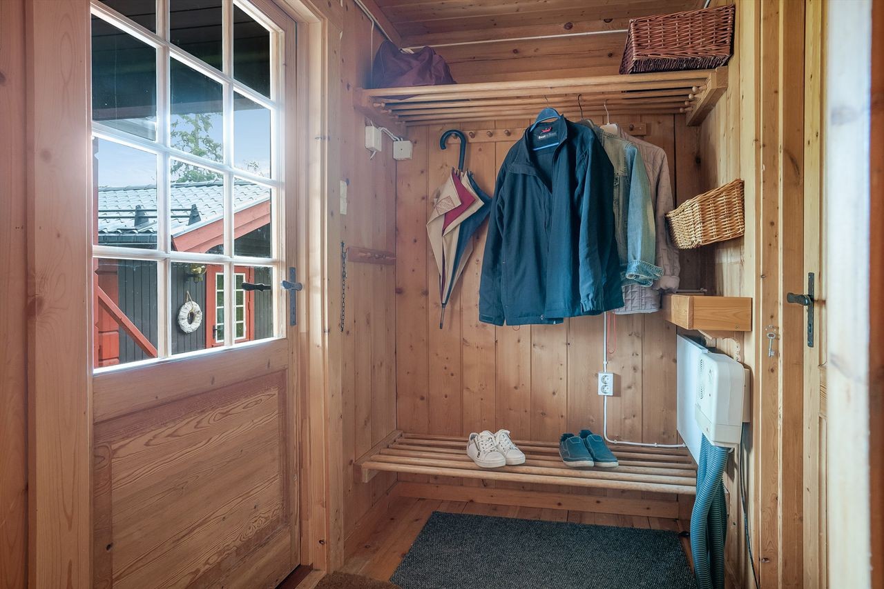 Entré med plass til yttertøy og sko, og med skotørker. Dør inn til stua og til en innvendig bod Galleribilde