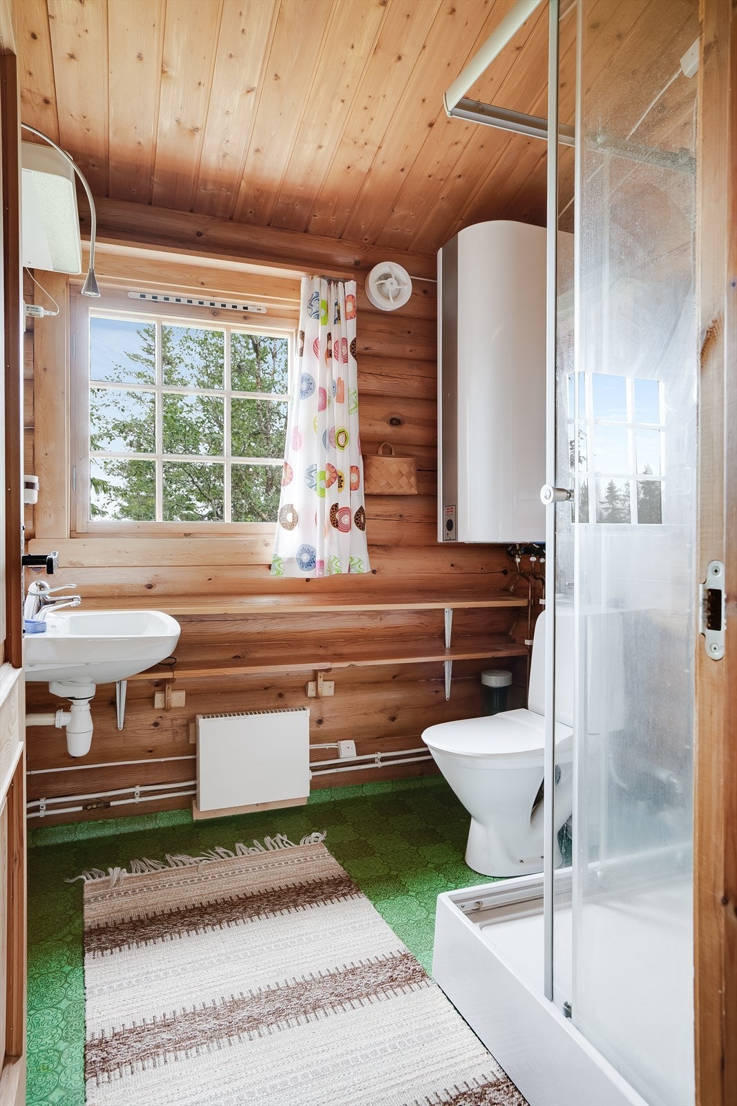 Bad med belegg, dusjkabinett, servant og wc. Varmtvannsbereder og mekanisk vifte. Galleribilde