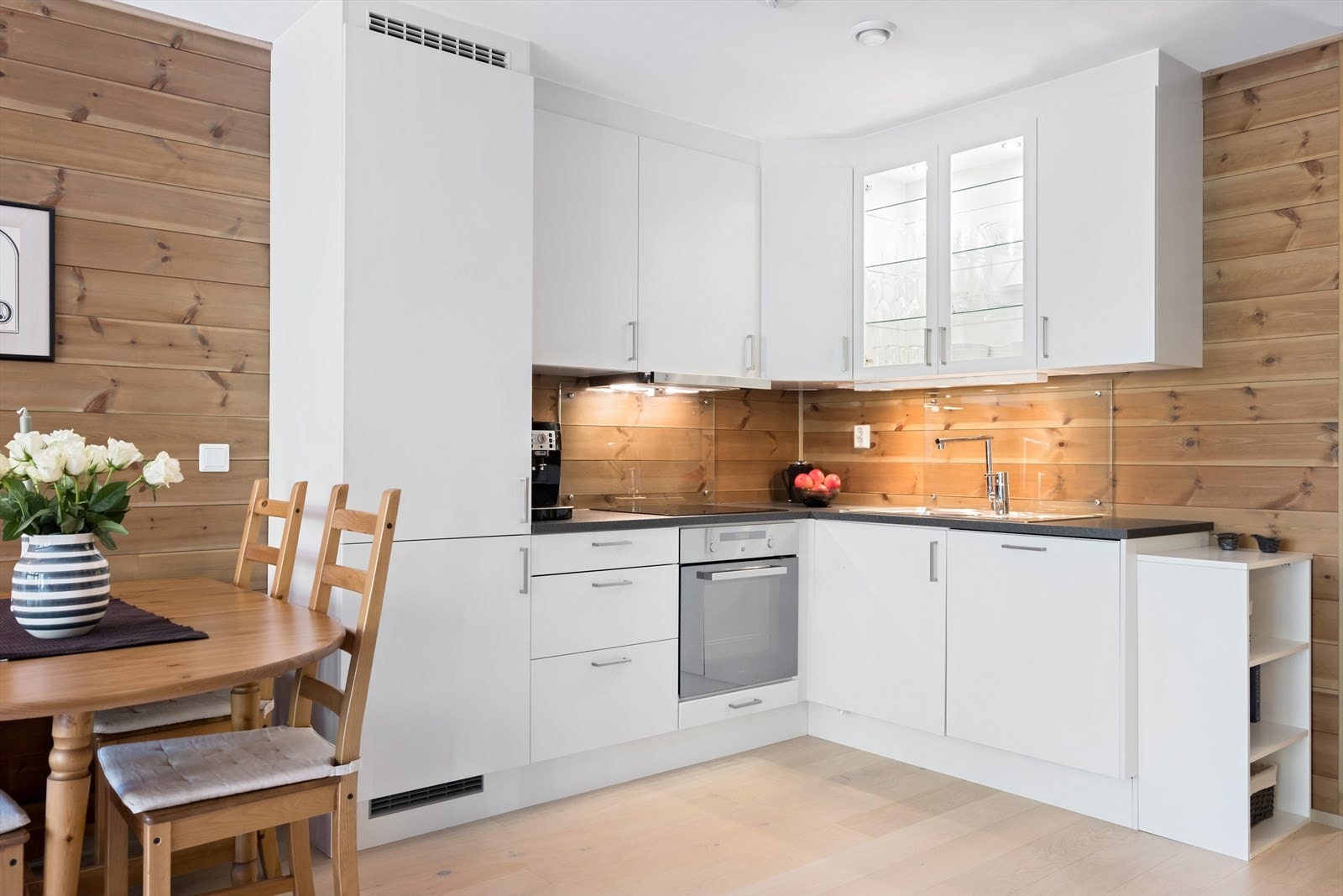 Lettstelt kjøkken med tidløse, hvite fronter, og mørkere benkeplate som en flott kontrast Galleribilde