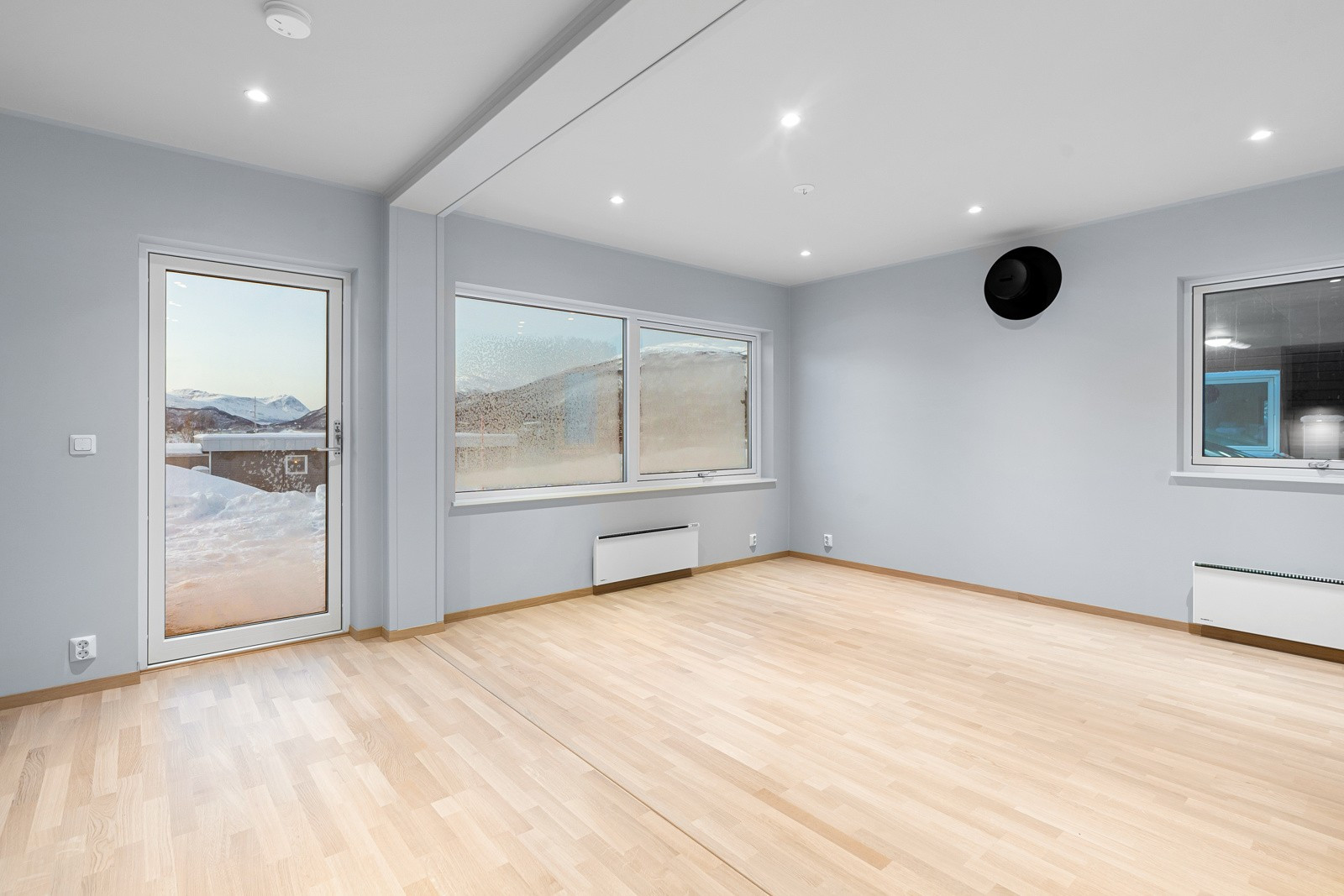 Stor stue med delikate farger og downlights i tak.