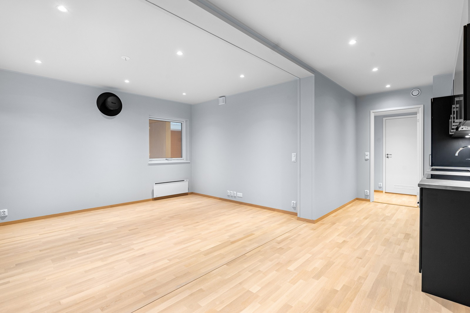 Stor stue med delikate farger og downlights i tak.