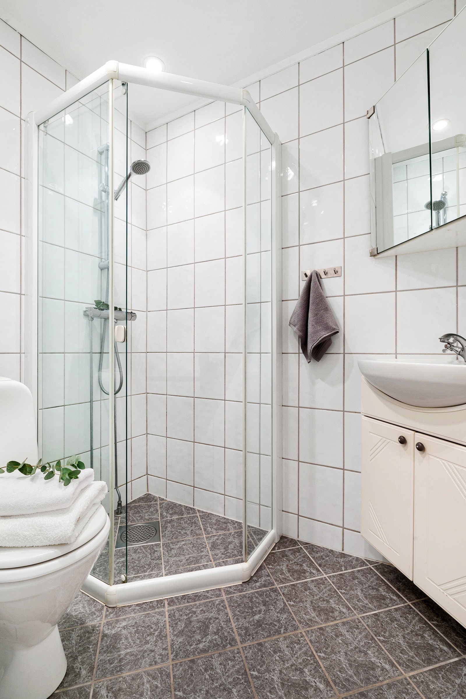 Badet inneholder dusjnisje, toalett og servantinnredning Galleribilde