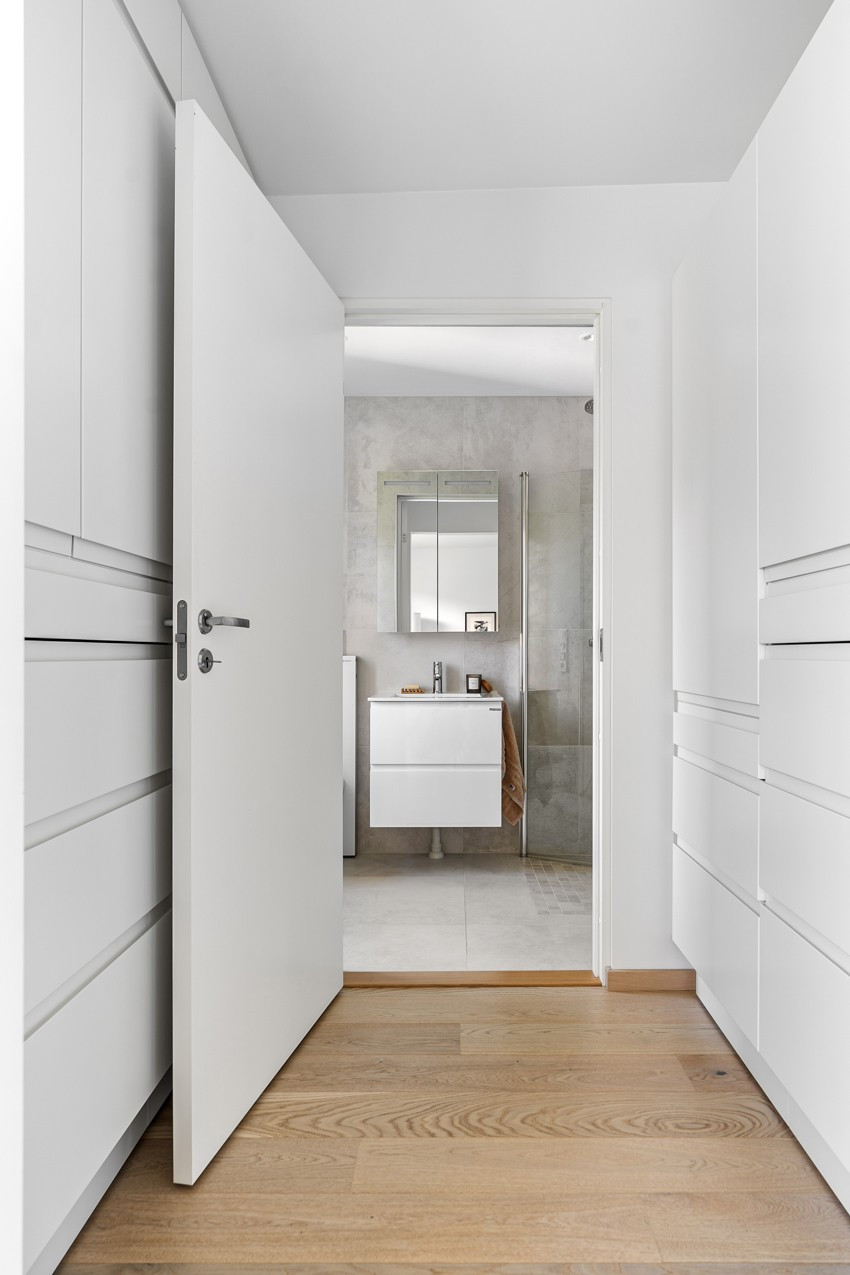 Walk-in closet fra hovedsoverom som fører inn til baderom 2.