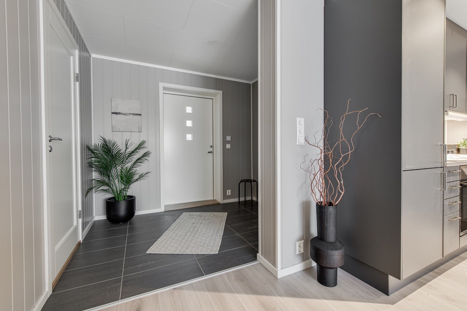 Velkommen inn i en romslig gang med inngang til bad, vaskerom/teknisk rom samt stue Galleribilde