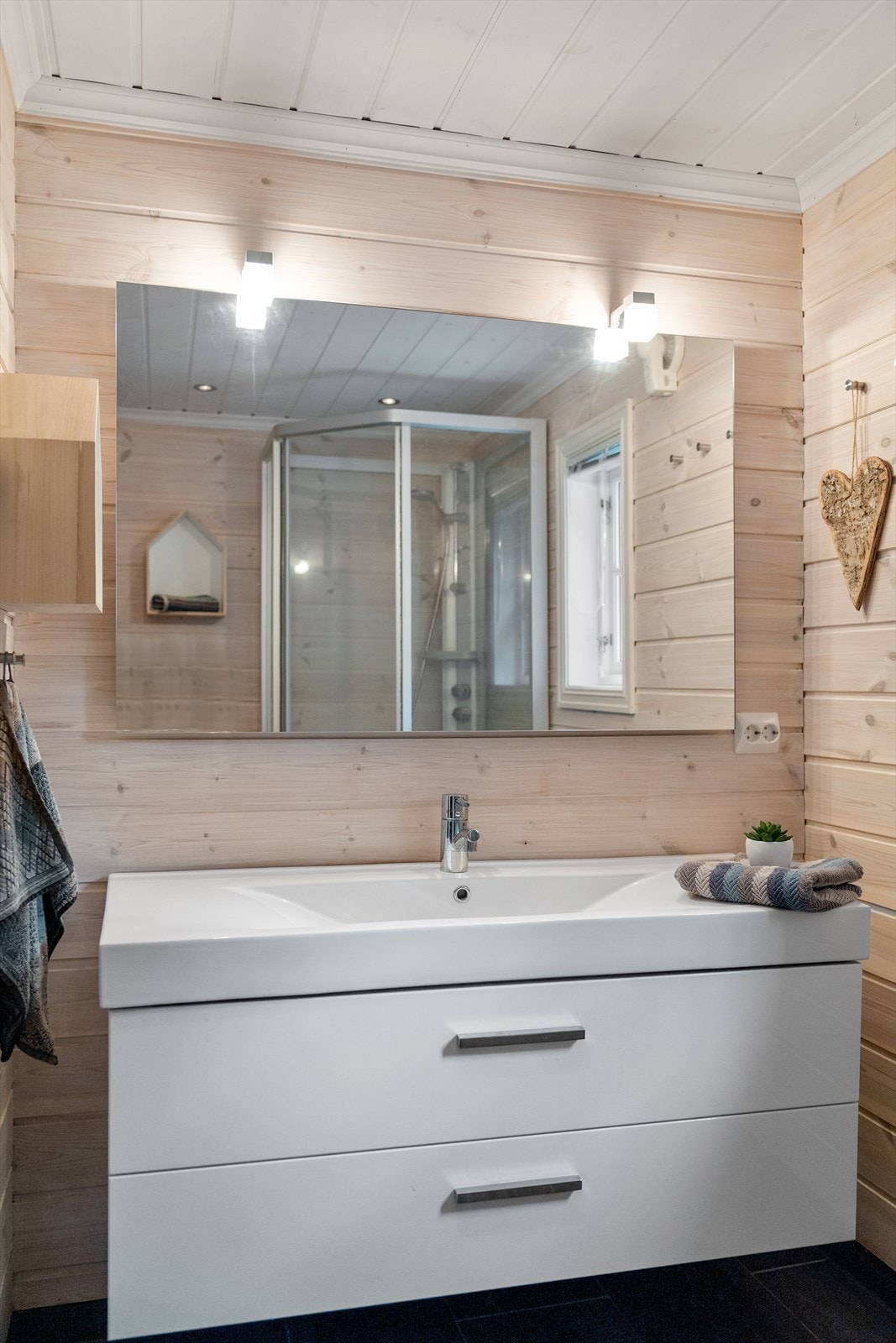 Praktisk og moderne bad med pene flis og varme i gulv. Fin kontrast mot lune panelvegger. Galleribilde