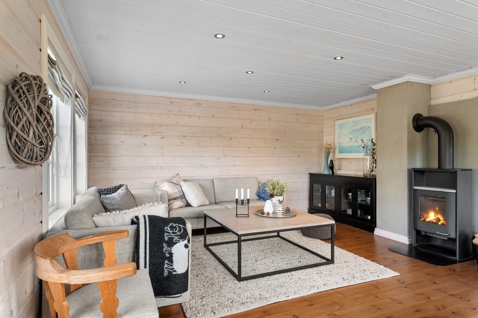 Romslig og lys hovedstue med peisovn for ekstra kos og varme. God plass til flere soner. Direkte utg til terrassen eller snøhuler. Galleribilde