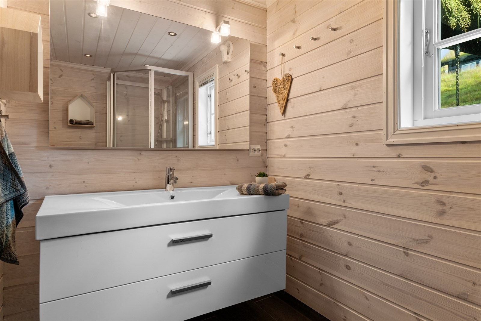 Praktisk og moderne bad med pene flis og varme i gulv. Fin kontrast mot lune panelvegger. Galleribilde