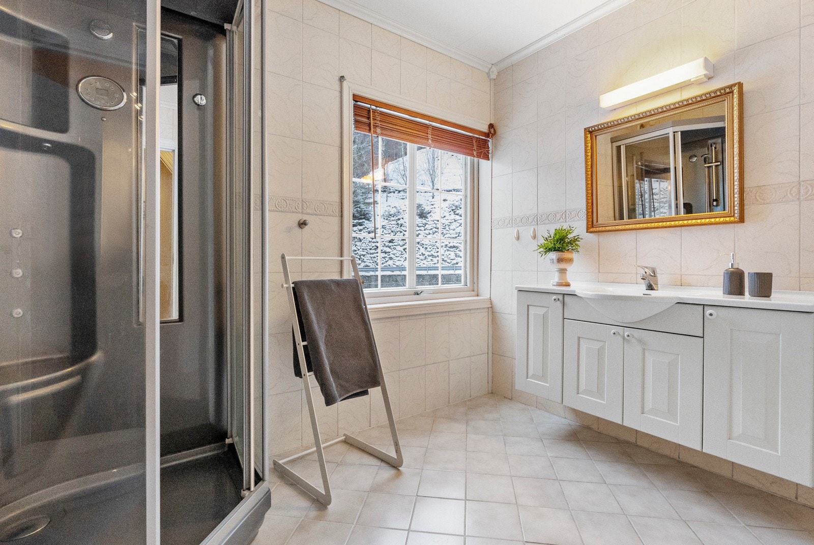 Badet ligger på hovedplan og har flislagt overflater og varmekabler i gulv Galleribilde