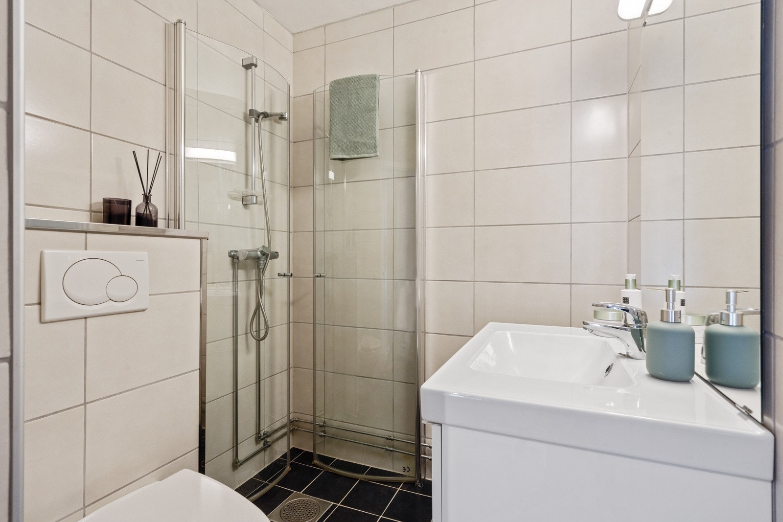 Lyst og delikat flislagt bad fra 2012 med en rekke kvaliteter som varme i gulv, vegghengt toalett og praktisk dusjhjørne Galleribilde