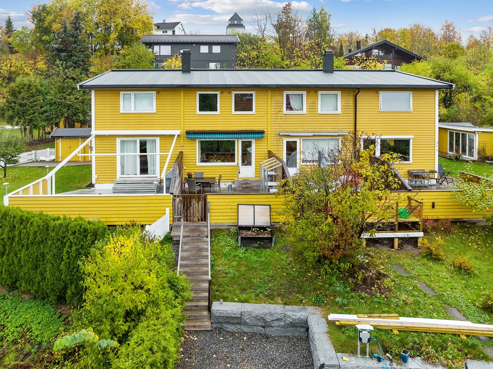 Hyggelig fasade, med veranda og trapp ned til parkeringsplass Galleribilde