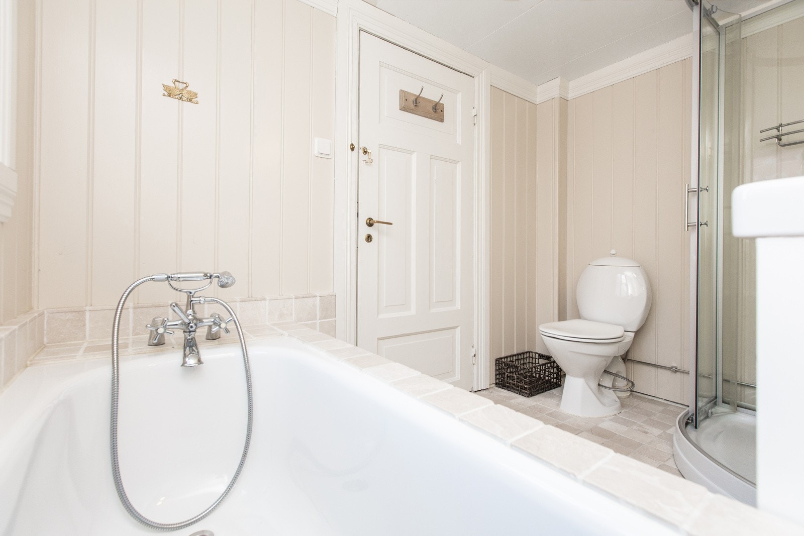 Bad med både badekar og dusj, vaskeservant og toalett. Galleribilde