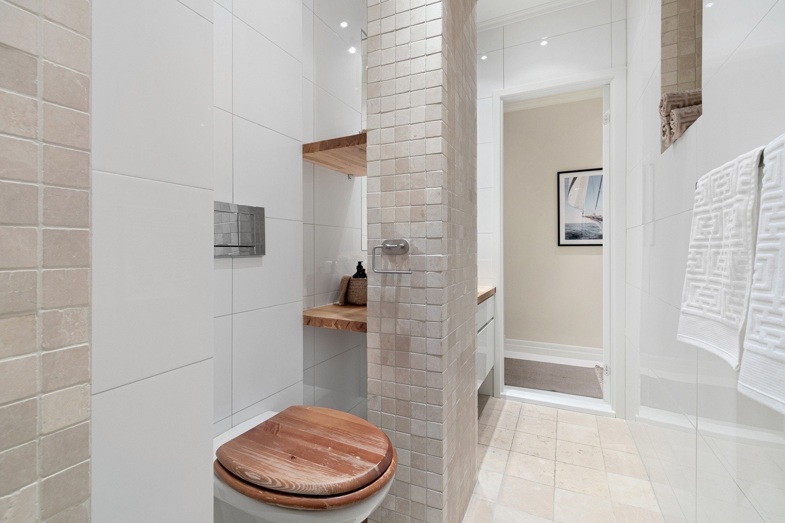 Badet er flott flislagt med mosaikkfliser i dusjone og på søyle. Galleribilde