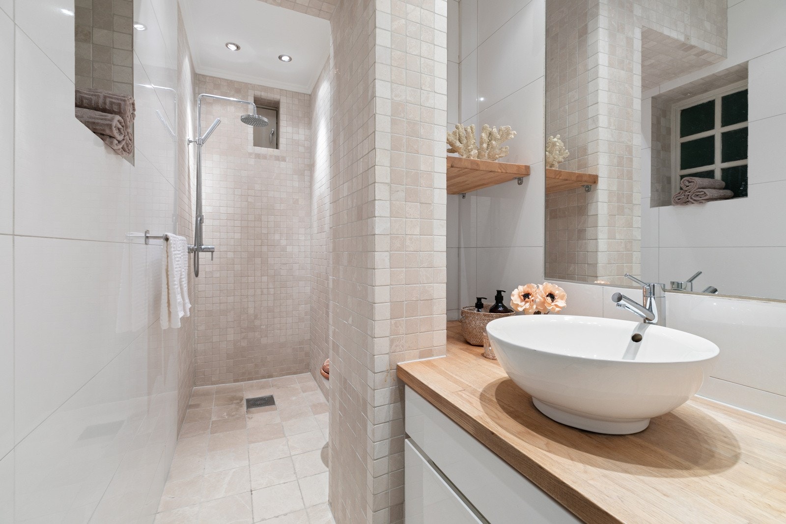 Flislagt baderom med behagelig gulvvarme, dusjnisje, veggmontert servantinnredning og toalett. Galleribilde