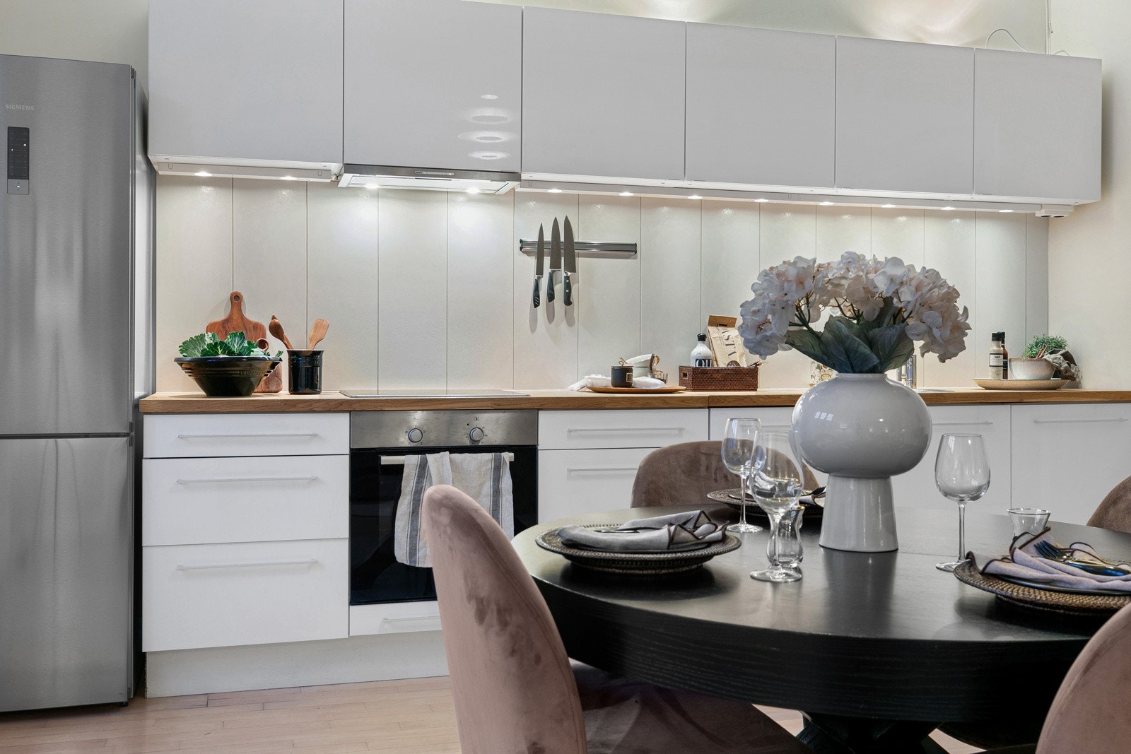 Kjøkkenet er innredet med heltre benkeplate med nedfelt rund stålkum og ett-greps armatur i krom samt overskap med benkebelysning og fliser på vegg. Galleribilde