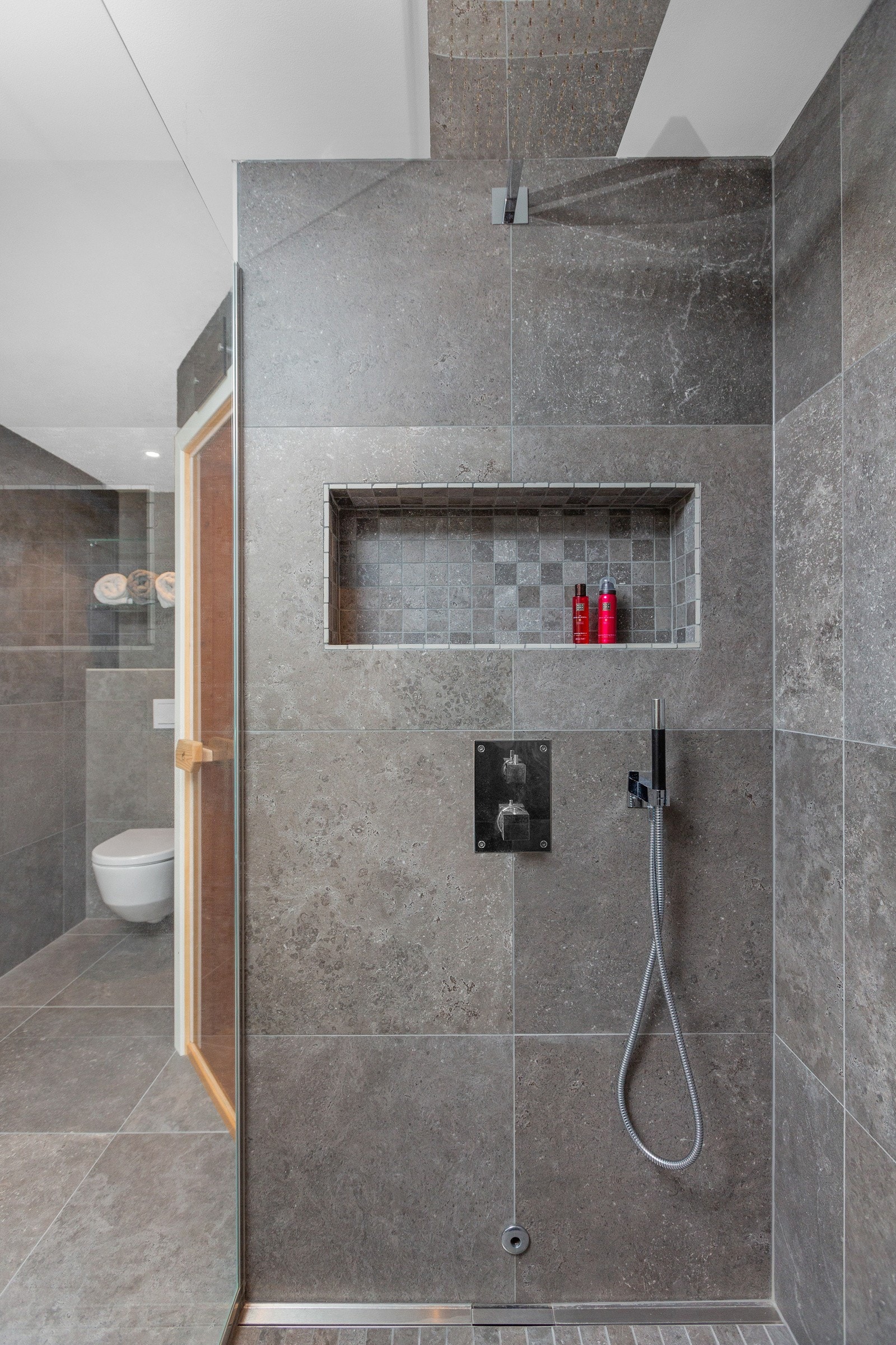 Stor regndusj med praktisk detalj, en innebygd vegghylle i dusjen. Galleribilde