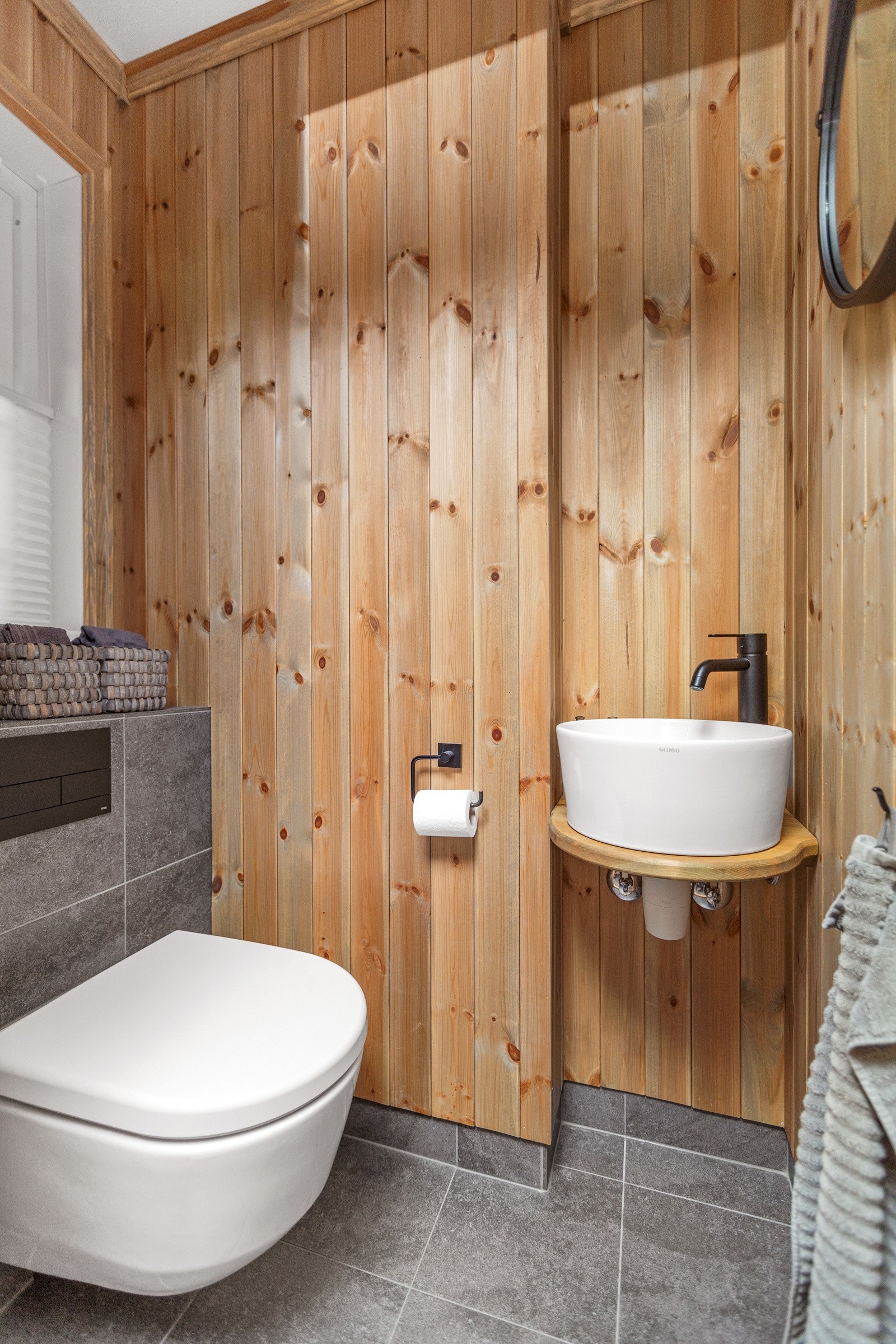 Toalettrommet ligger i tilknytning til utgangsdøra, praktisk med flislagt gulv, vegghengt toalett og lekker håndvask. Galleribilde