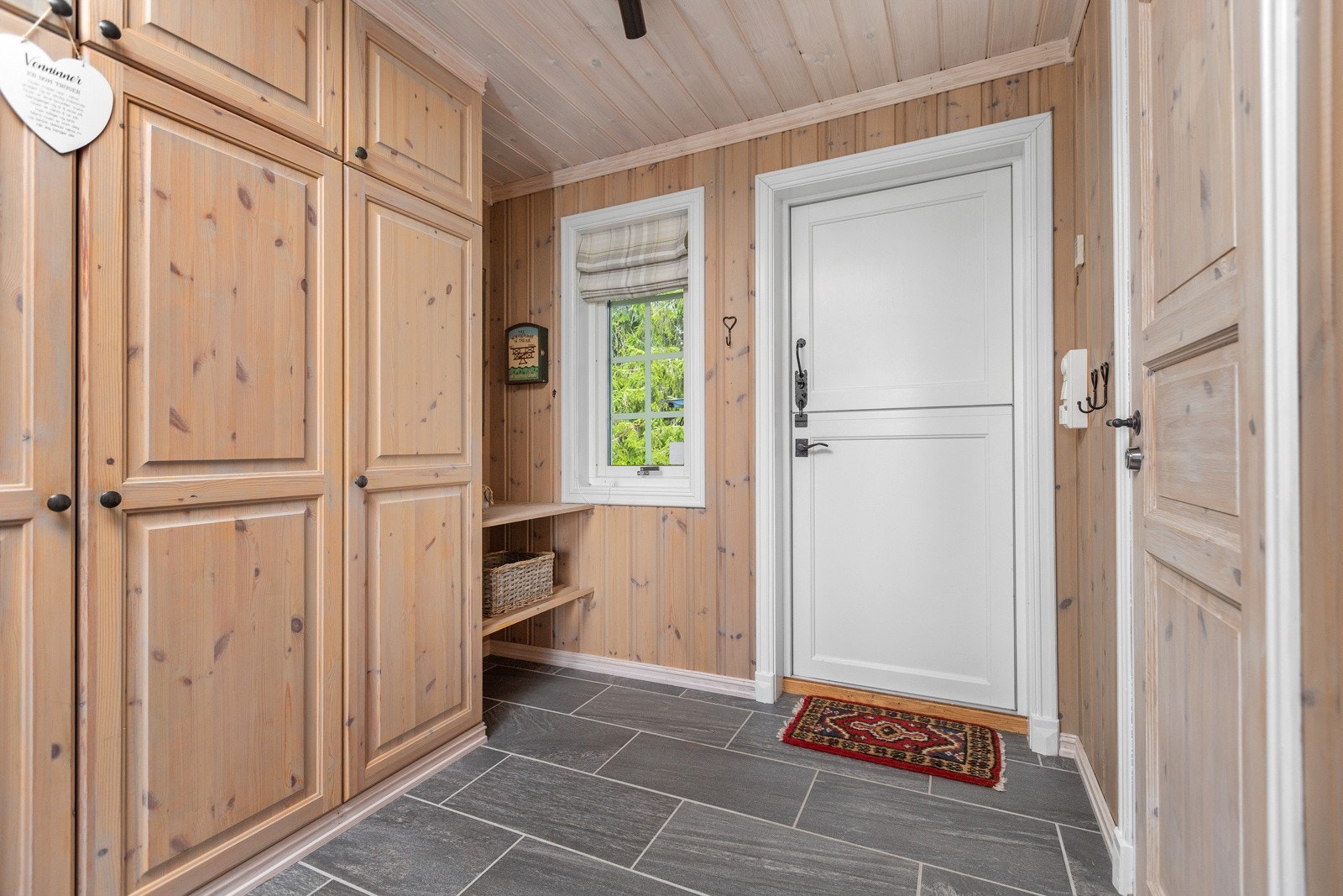 Fjøsdør, som er todelt, praktisk hylleanordning samt skap med mye oppbevaringsmuligheter Galleribilde