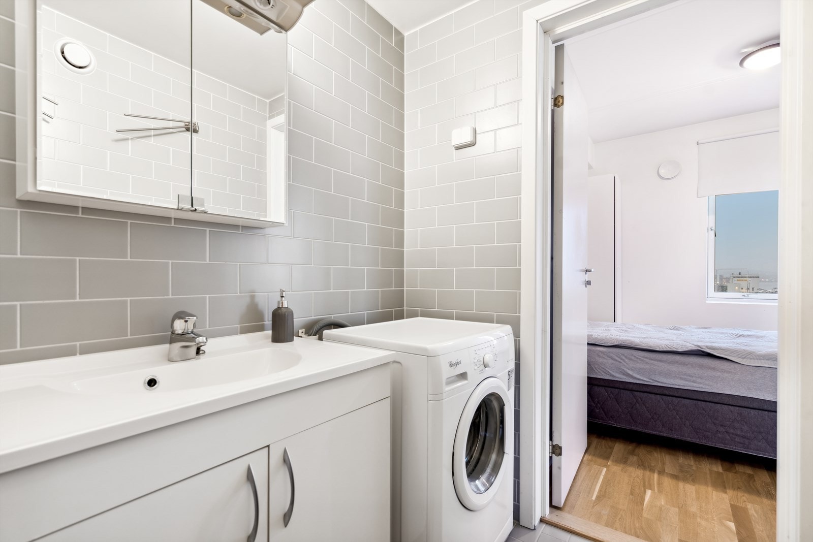 Her finner man vegghengt toalett, dusjnisje, opplegg for vaskmaskin og innredning med servant, underskap og overskap med speilfronter Galleribilde