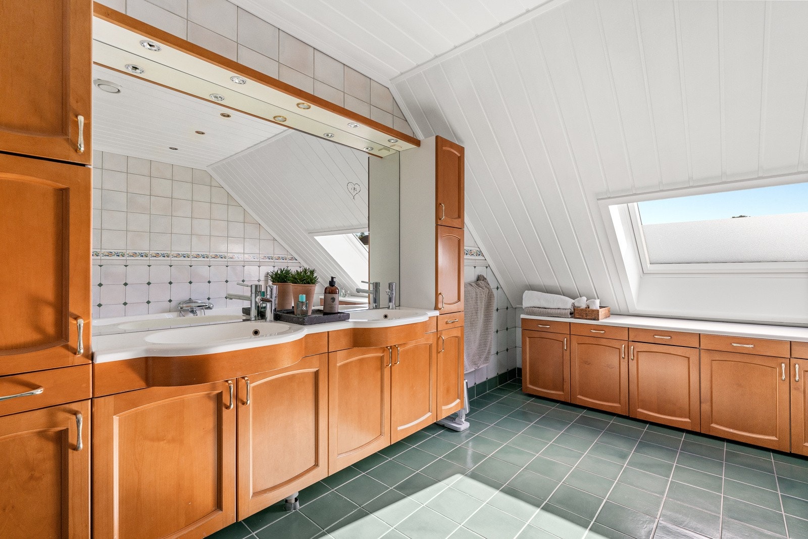 Baderom i tilknytning til hovedsverommet med kirsebærfargede fronter, gulvfliser og gulvvarme. Galleribilde