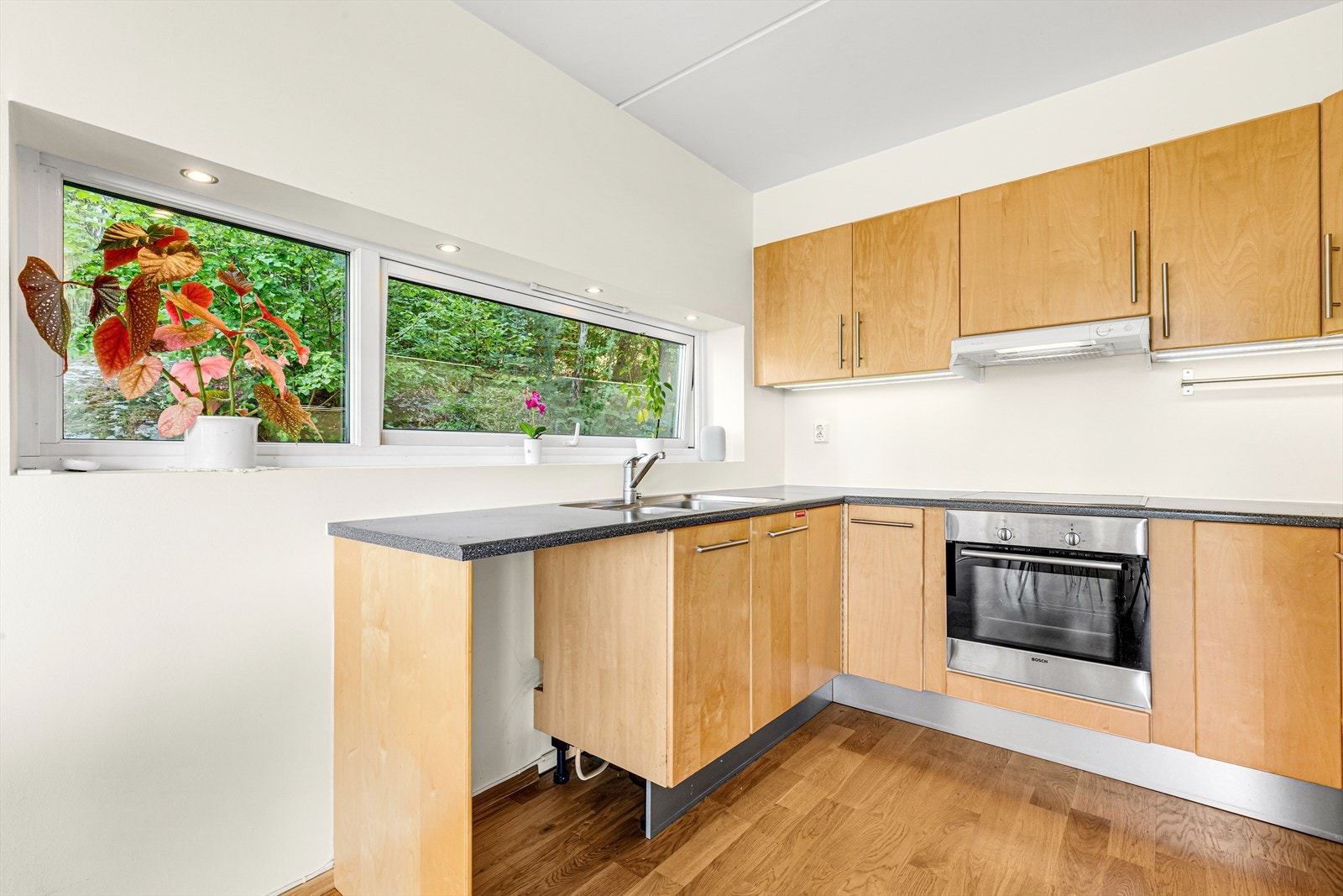 Sigdal kjøkken fra 2005 med kjøkkeninnredning bestående av slette trefronter og laminat benkeplate. Galleribilde